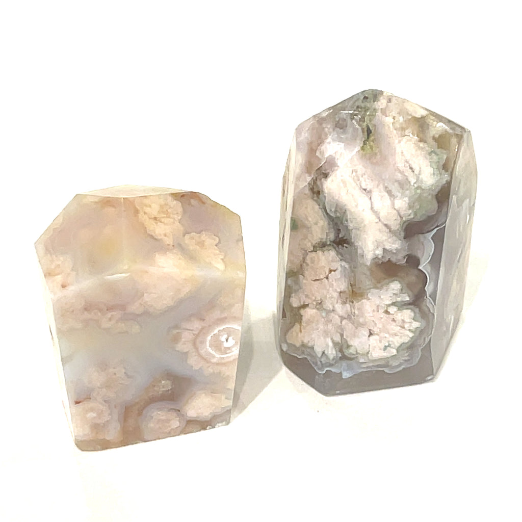 A collection of two free-form Flower Agate gemstones with varying shades of brown, green, and white patterns, and on a white background, front overview.