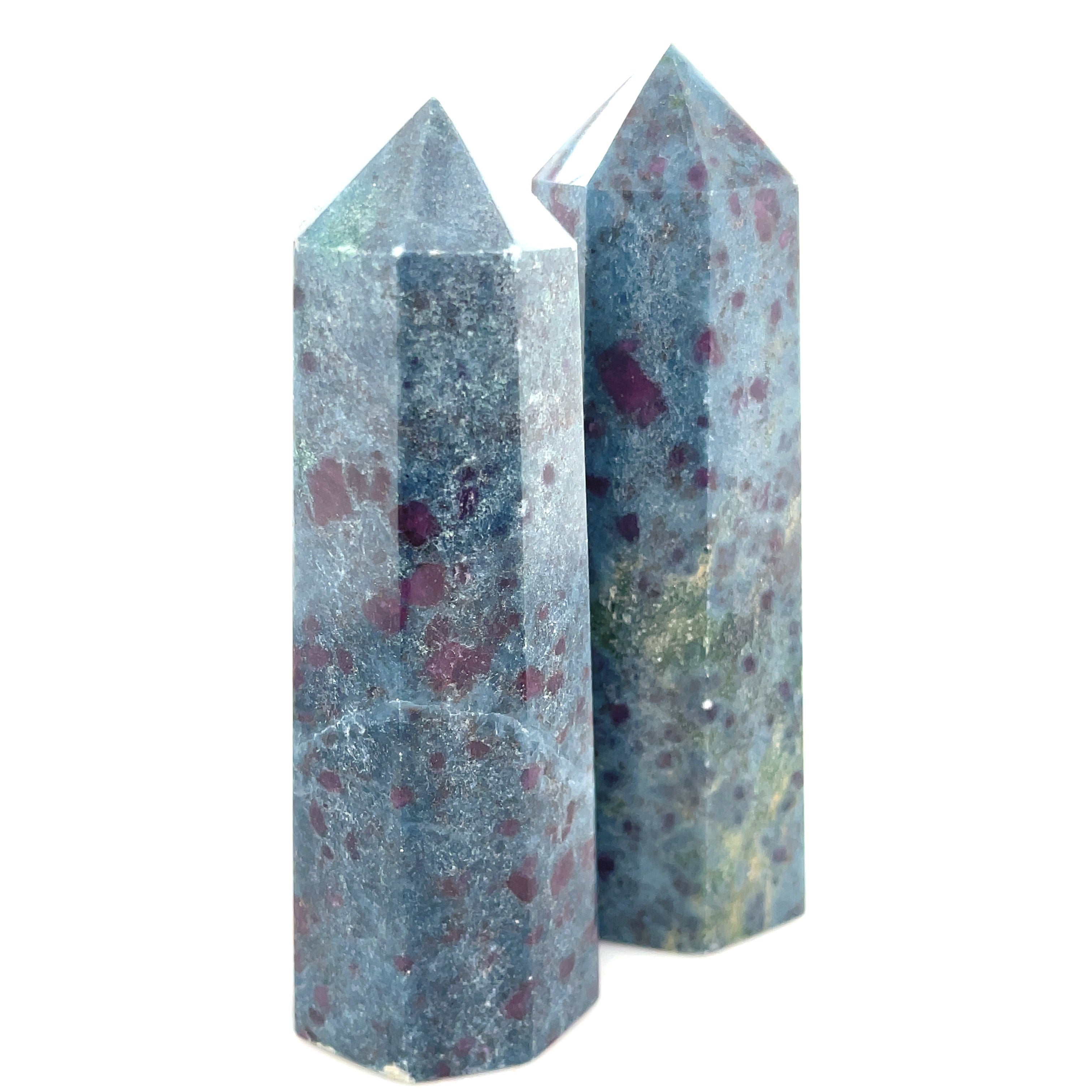 A collection of two tall  Ruby Kyanite gemstone towers with a deep blue color and red speckles, displayed on a white background, front close up overview.
