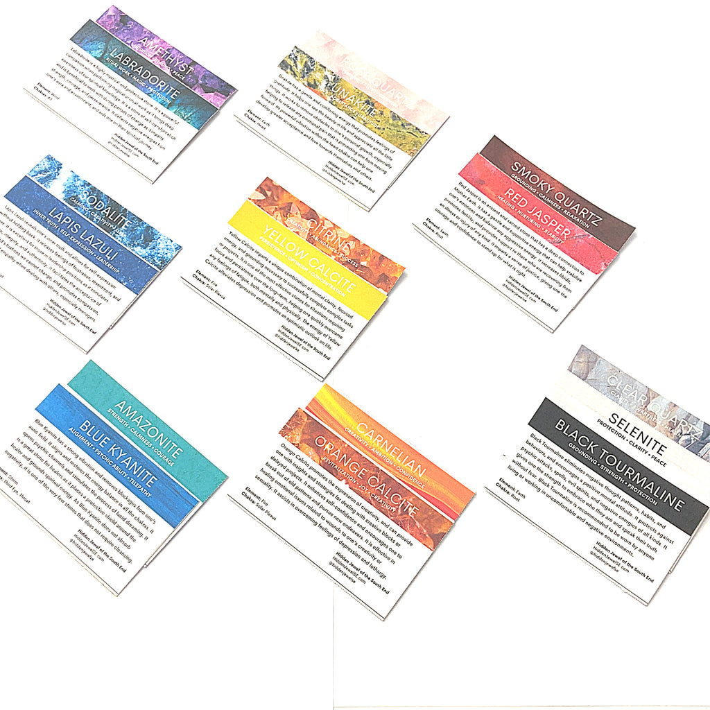 A collection of various raw gemstones information cards from the Chakra bag. on a white background in a front overview.
