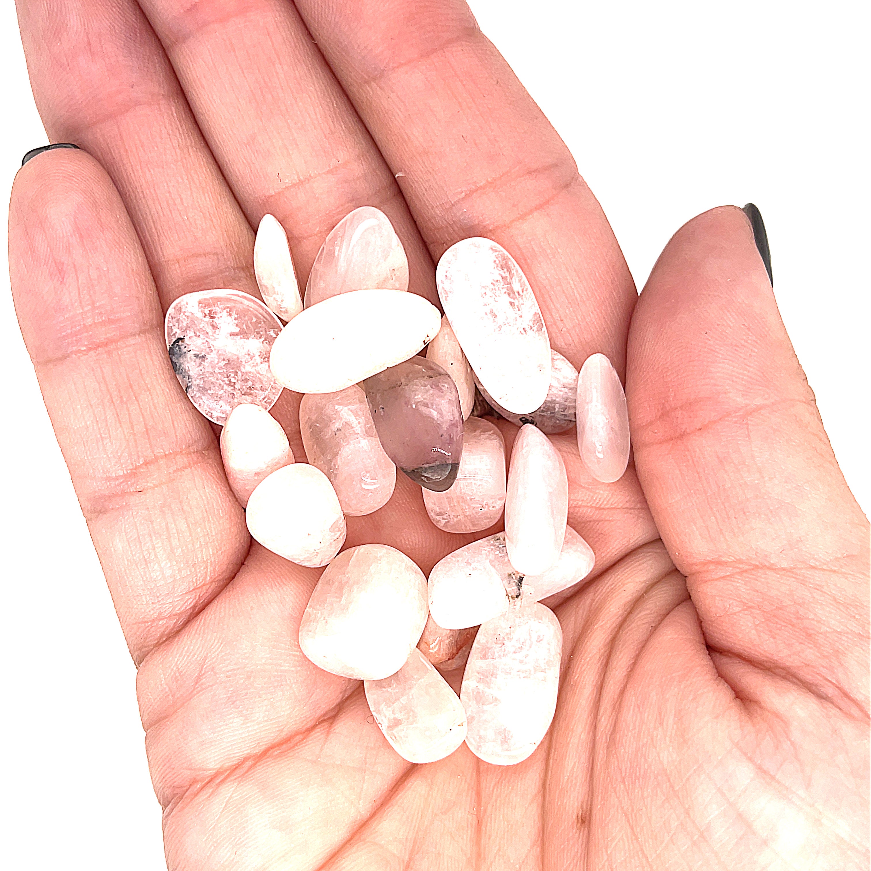A collection of xs tumbled Petalite gemstones with a pink hue, displayed  in a models palm on a white background, front overview.