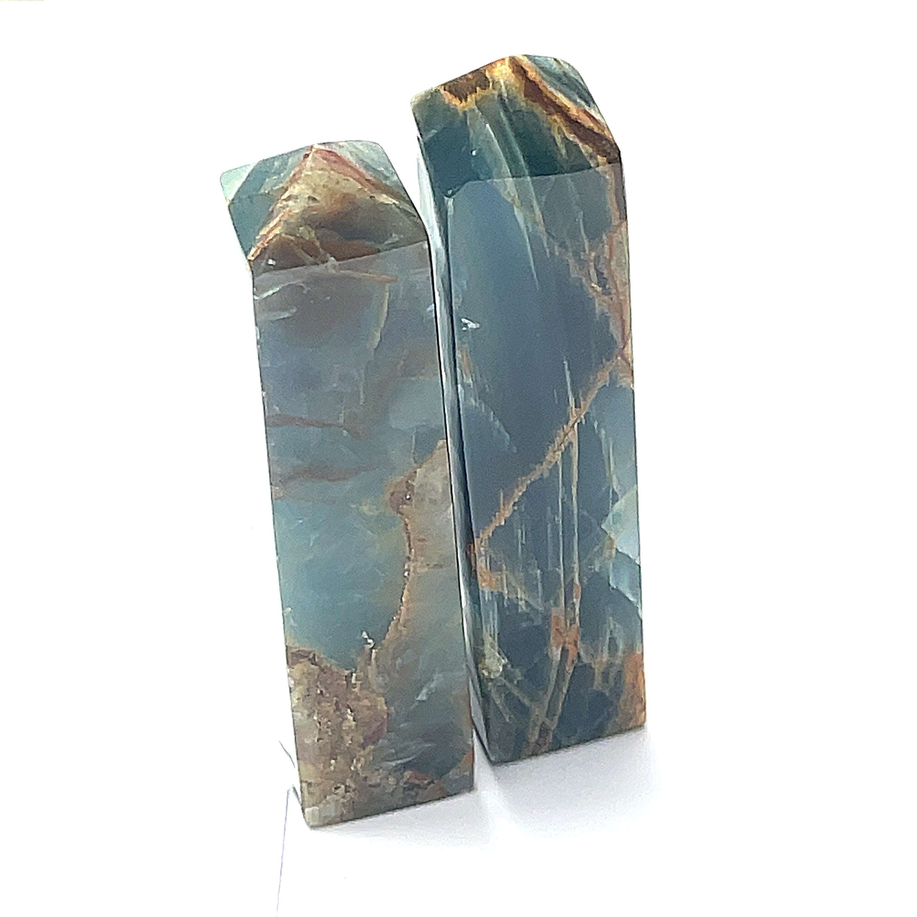A collection of xtra large sizes of  blue onyx gemstone towers displayed in a group on a white background, front overview.