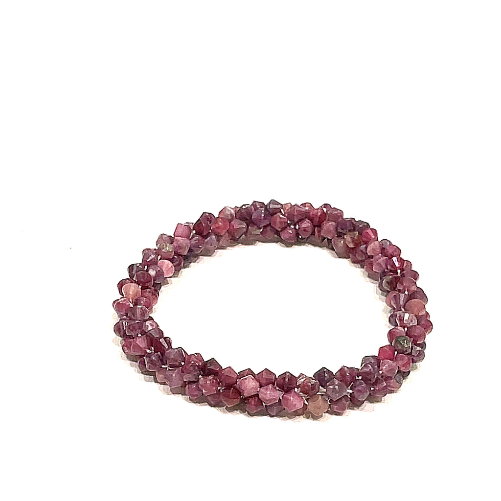 A crocheted bracelet made of pink tourmaline gemstones on a white background, front overview. 