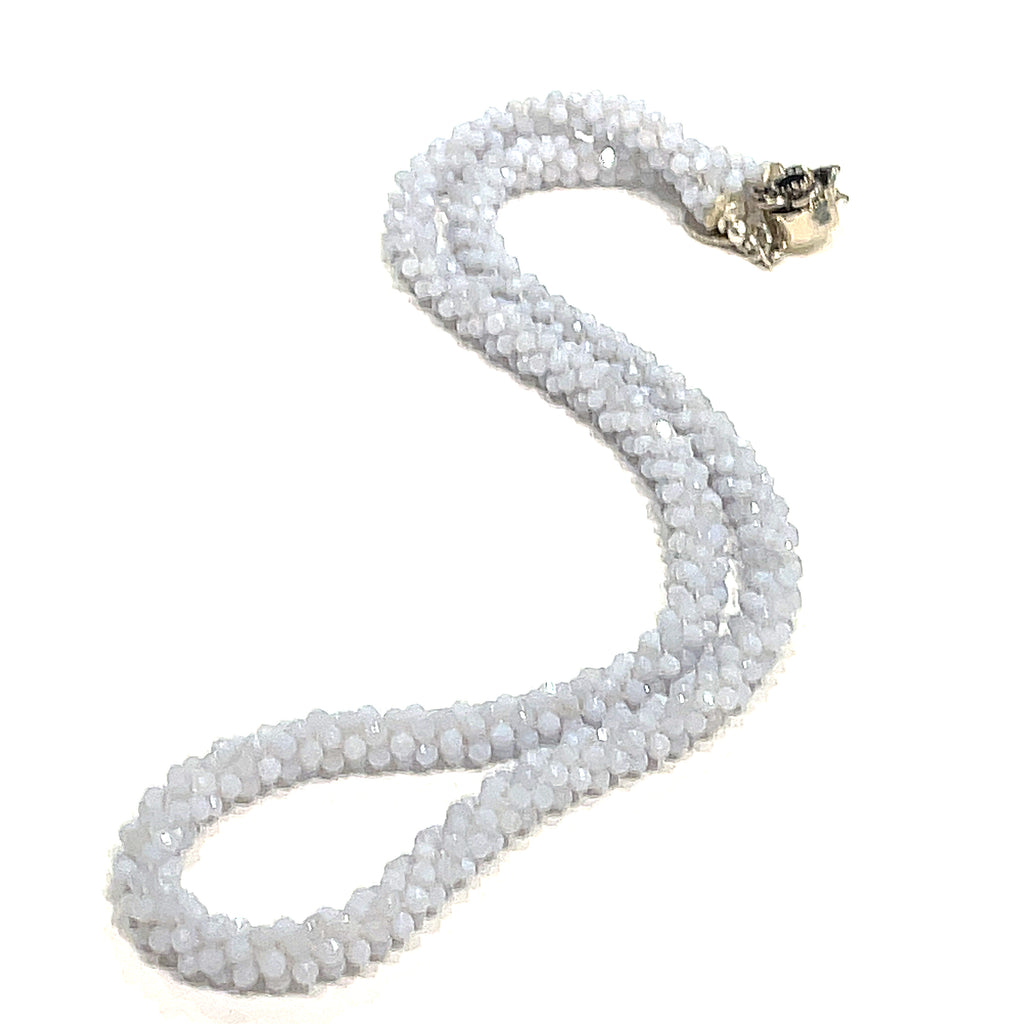 A crocheted necklace made with blue chalcedony gemstones on a white background, long, front overview.