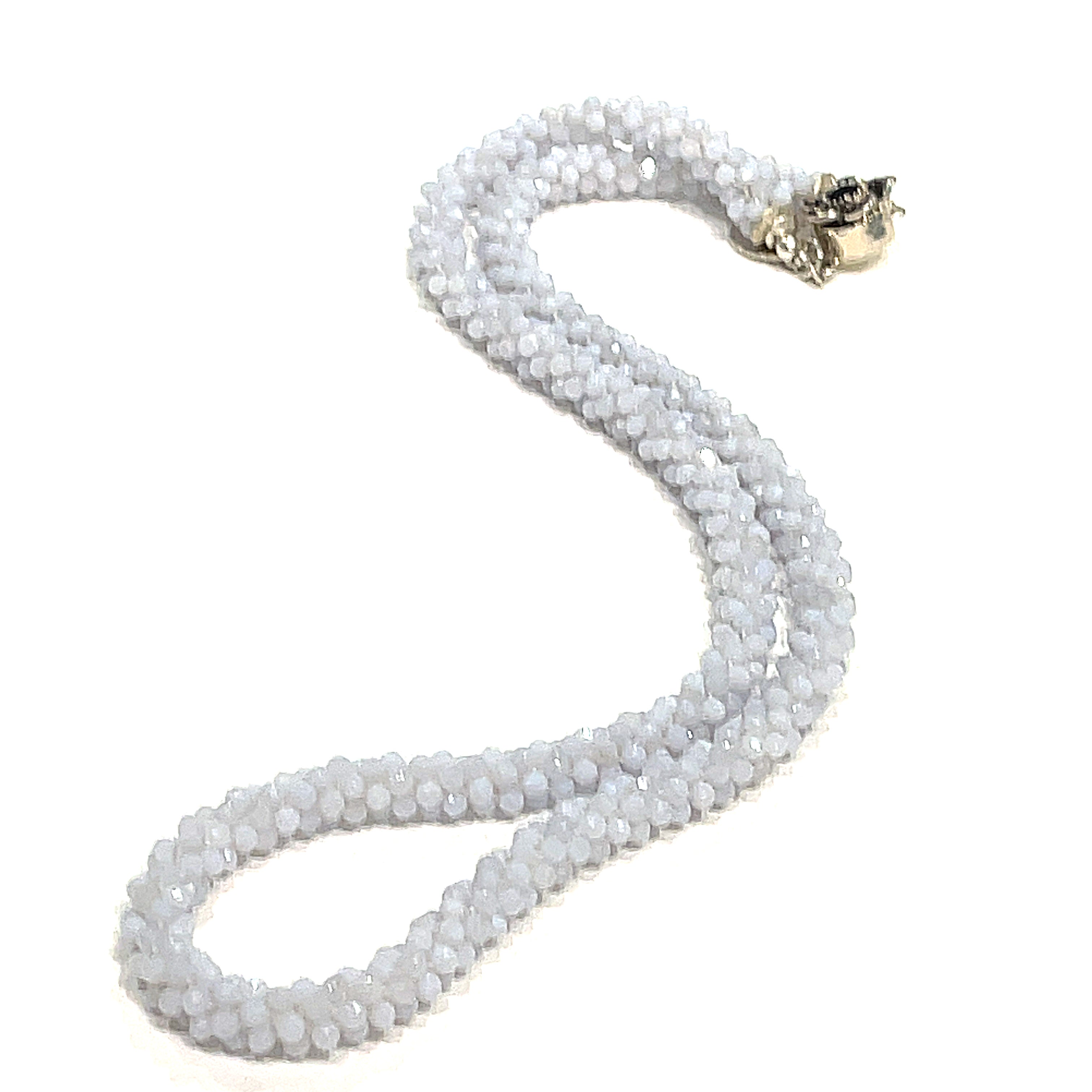 A crocheted necklace made with blue chalcedony gemstones on a white background, long, front overview.