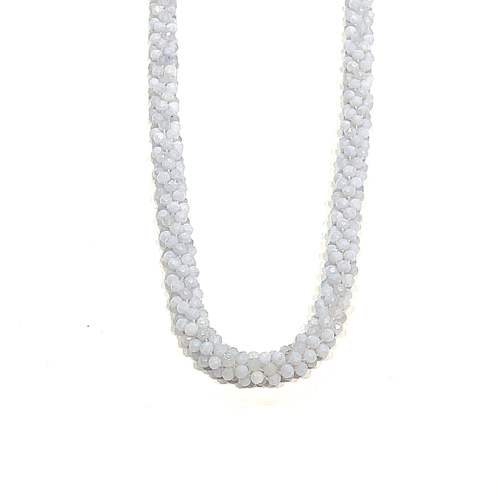 A crocheted necklace made with blue chalcedony gemstones on a white background, long, hanging front overview.