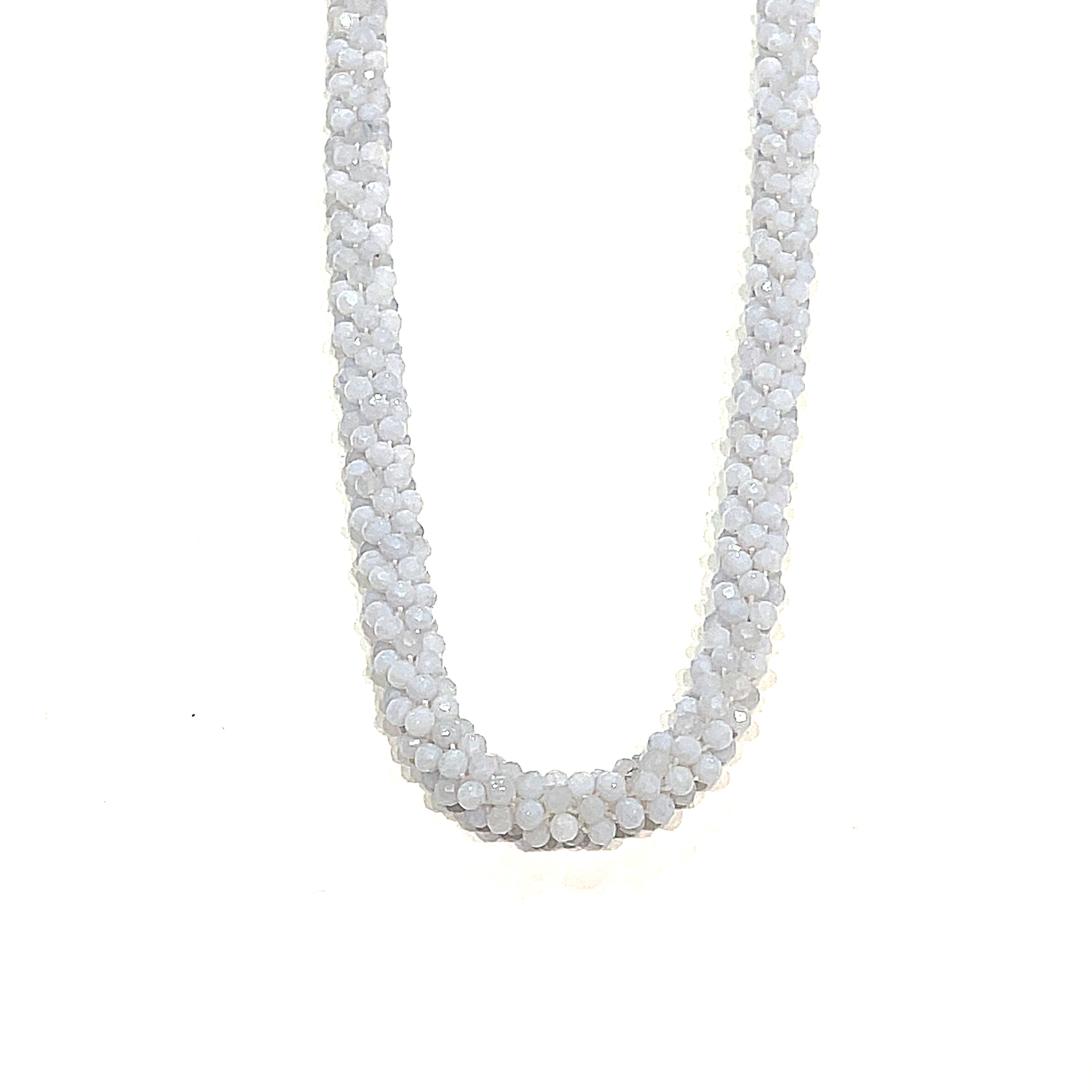 A crocheted necklace made with blue chalcedony gemstones on a white background, long, hanging front overview.