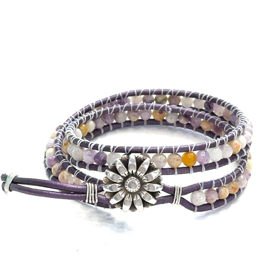 A double leather wrap bracelet made out of purple flower agate, featuring a floral button, and measuring 15.5 inches in length. On a white background button view.