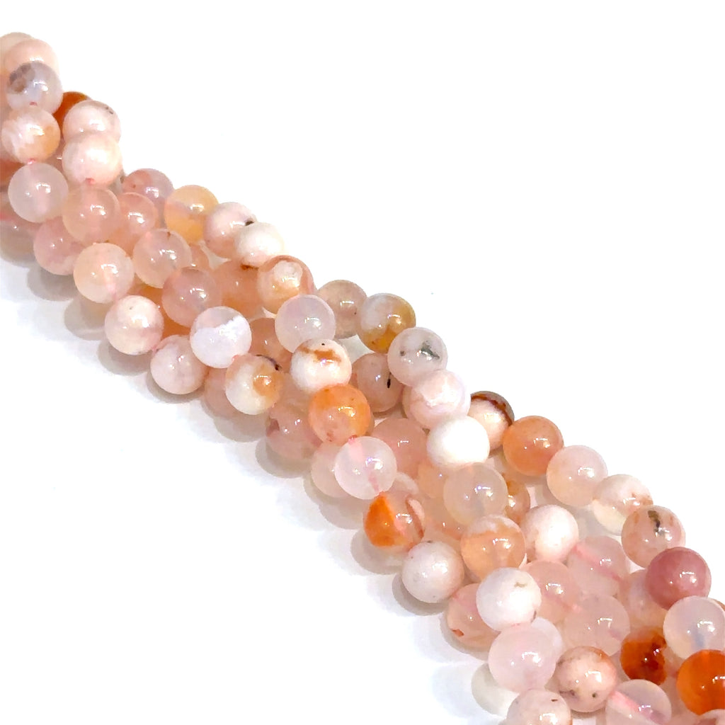 A flower agate gemstone strand 6mm smooth round on a white background front overview. 