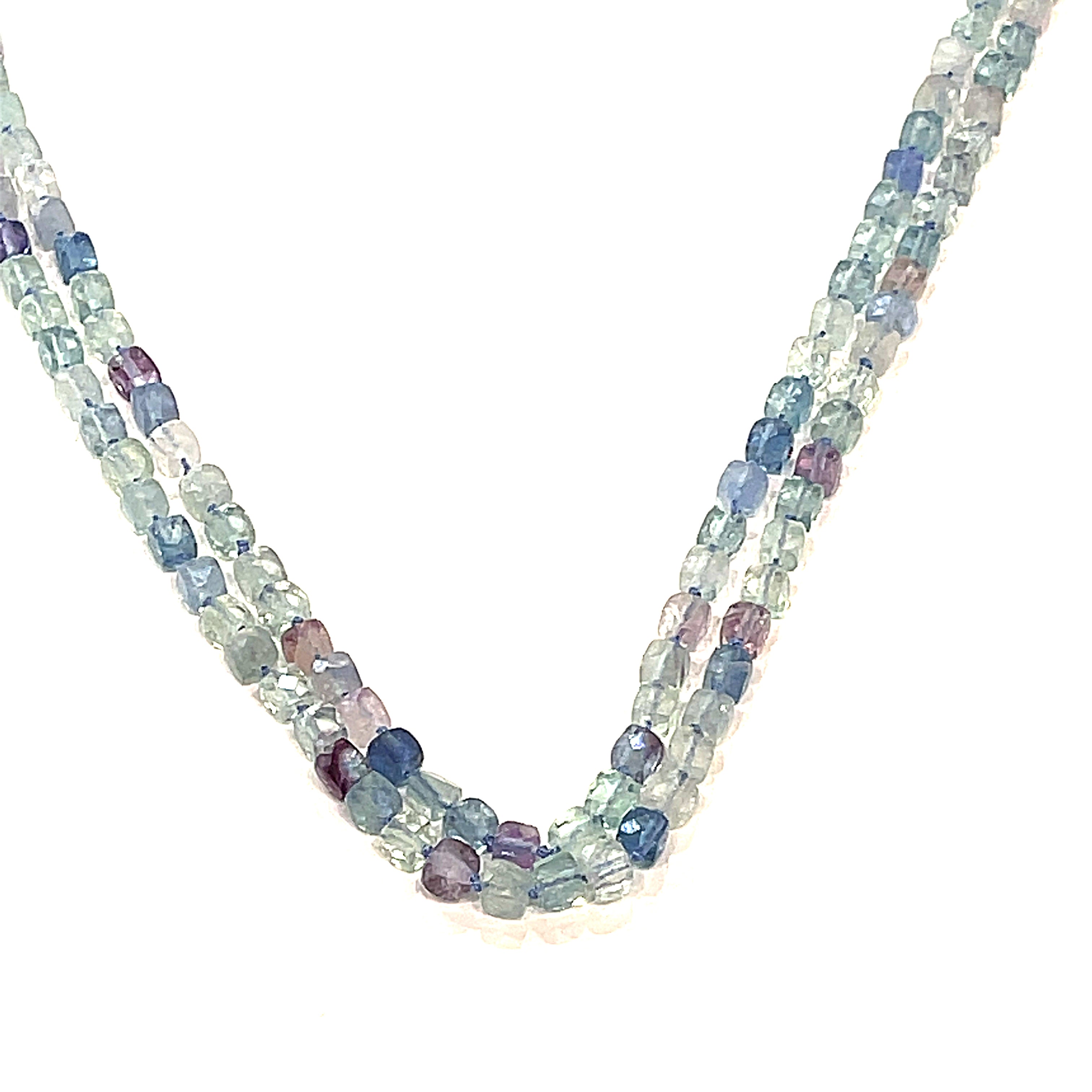 A fluorite gemstone knotted necklace with a sterling silver toggle clasp, beaded on silk beading cord, hanging up overview on a white background.