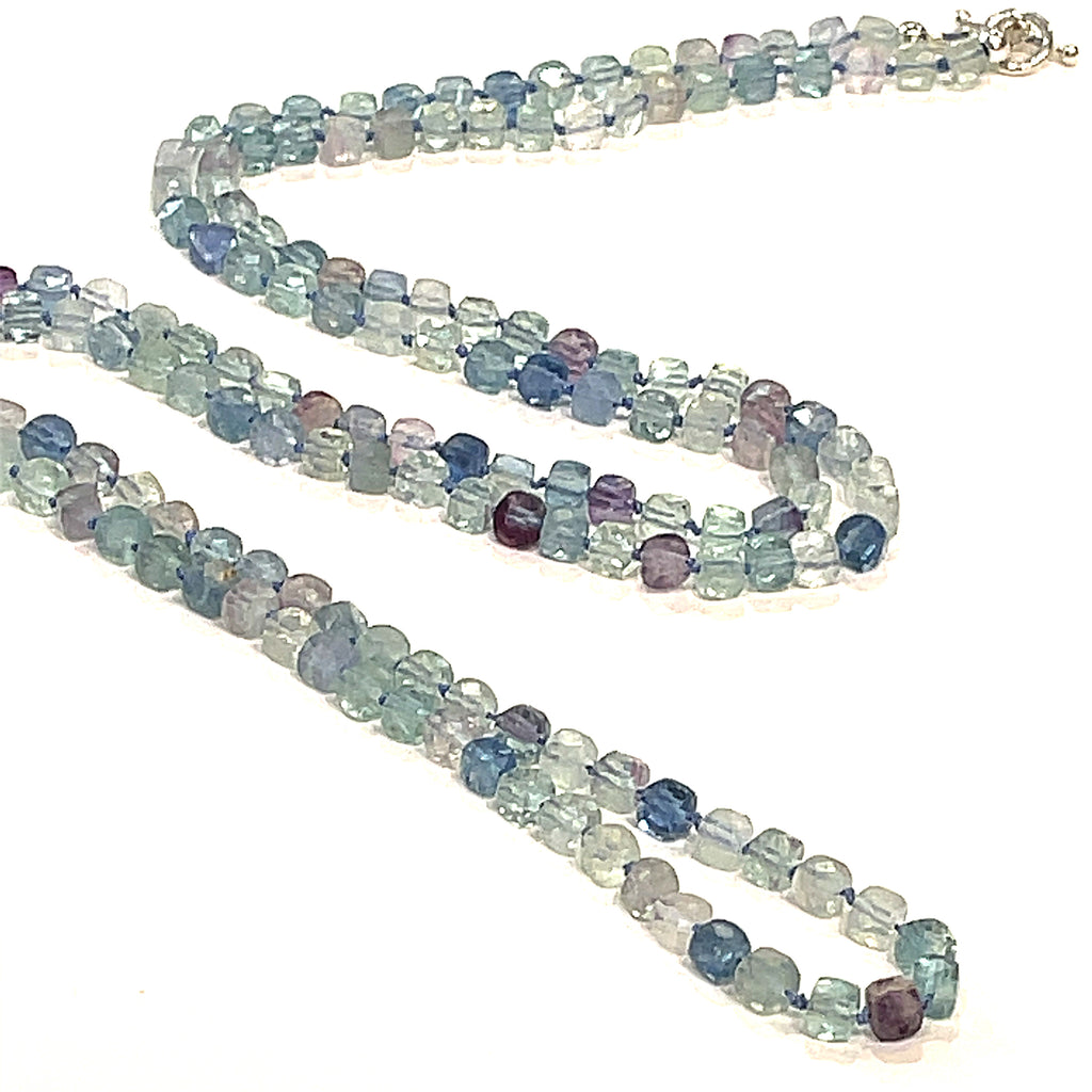 A fluorite gemstone knotted necklace with a sterling silver toggle clasp, beaded on silk beading cord, long front overview on a white background.