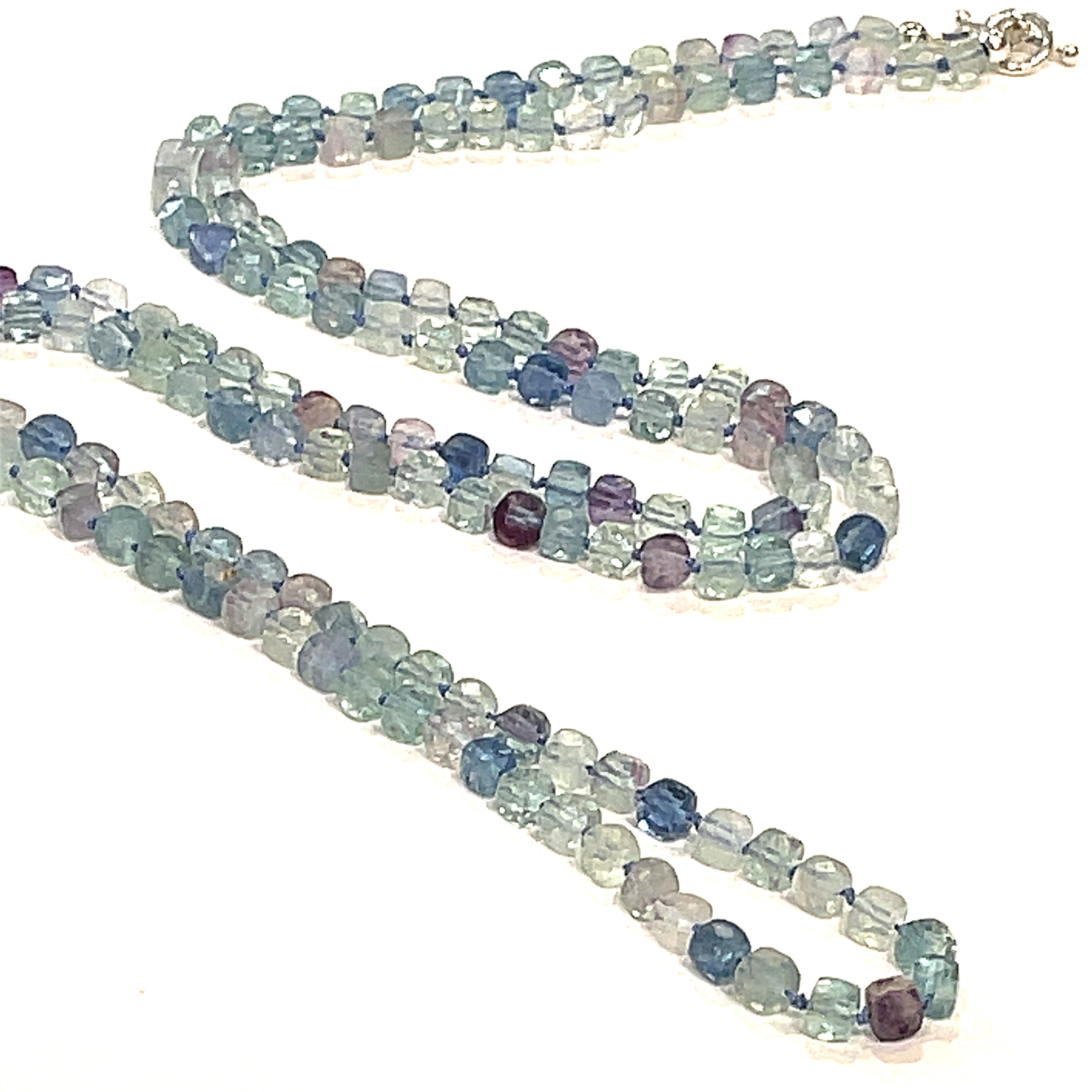 A fluorite gemstone knotted necklace with a sterling silver toggle clasp, beaded on silk beading cord, long front overview on a white background.