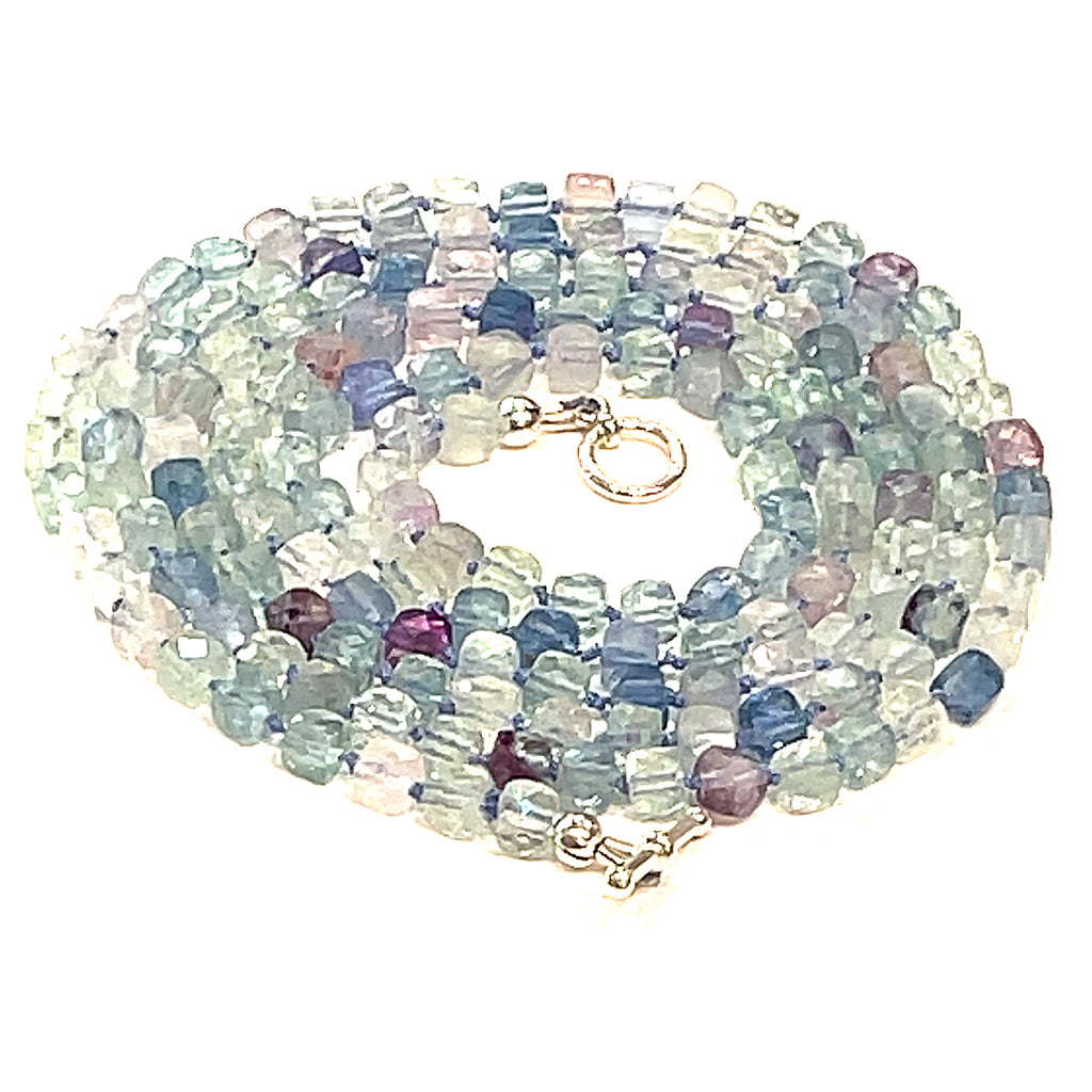 A fluorite gemstone knotted necklace with a sterling silver toggle clasp, beaded on silk beading cord, spiral close up overview on a white background.