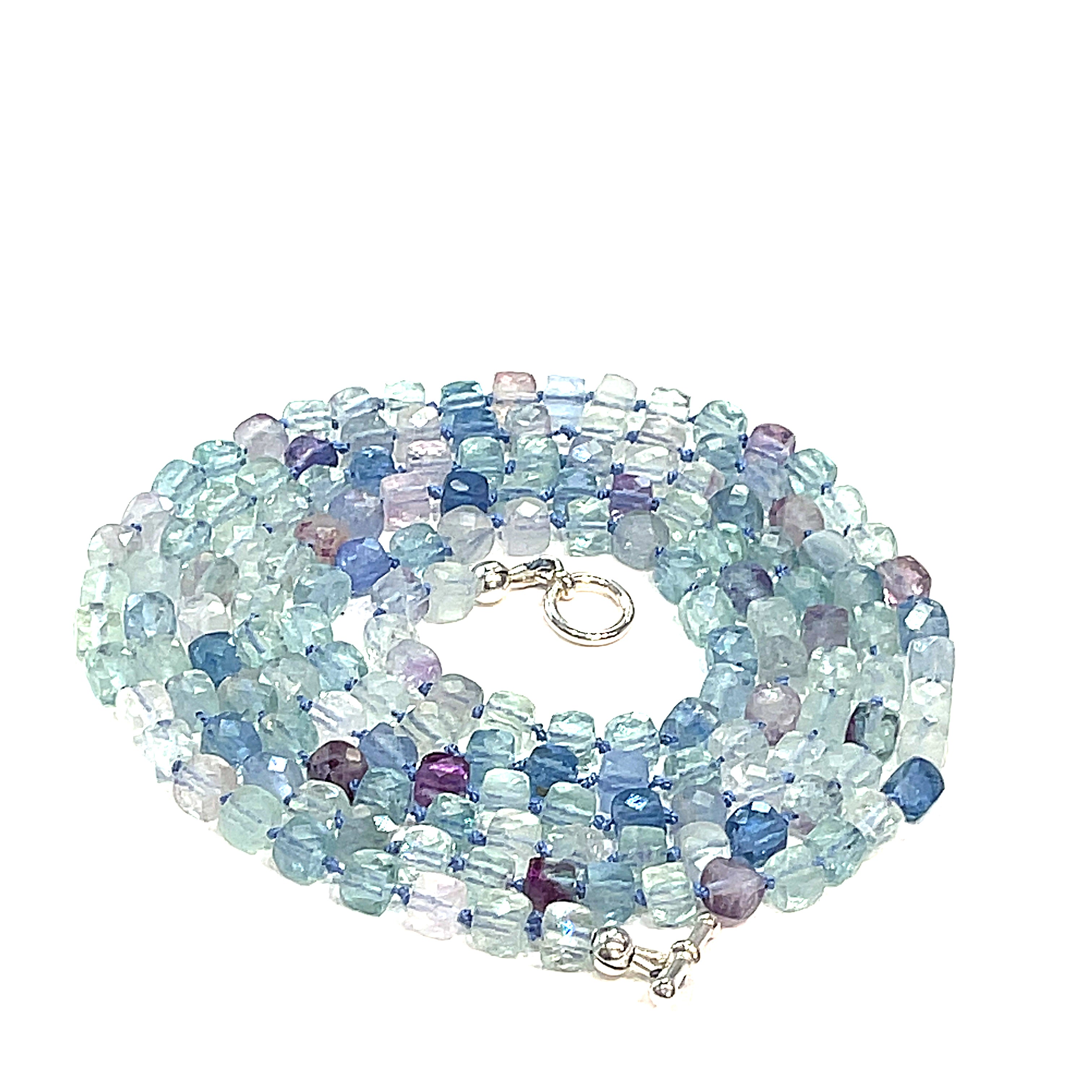 A fluorite gemstone knotted necklace with a sterling silver toggle clasp, beaded on silk beading cord, spiral overview on a white background.