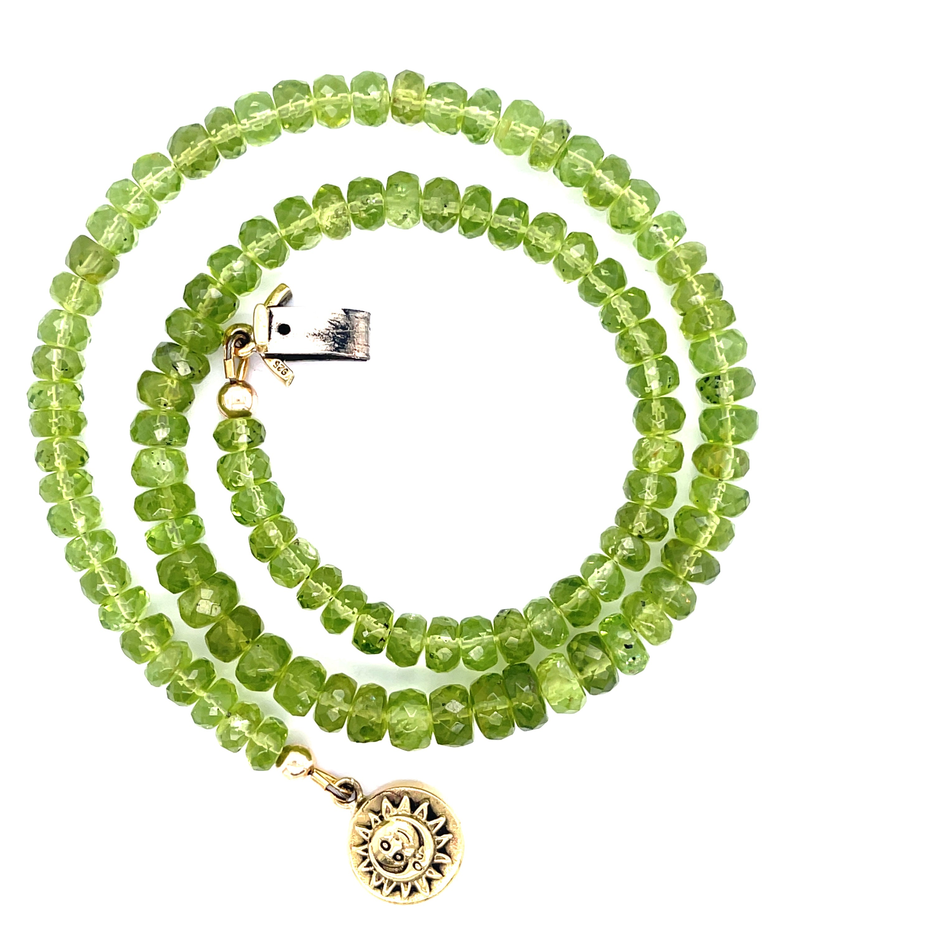 A green beaded peridot gemstone necklace with gold-filled findings and a sun and moon box clasp on a white background, spiral overview.