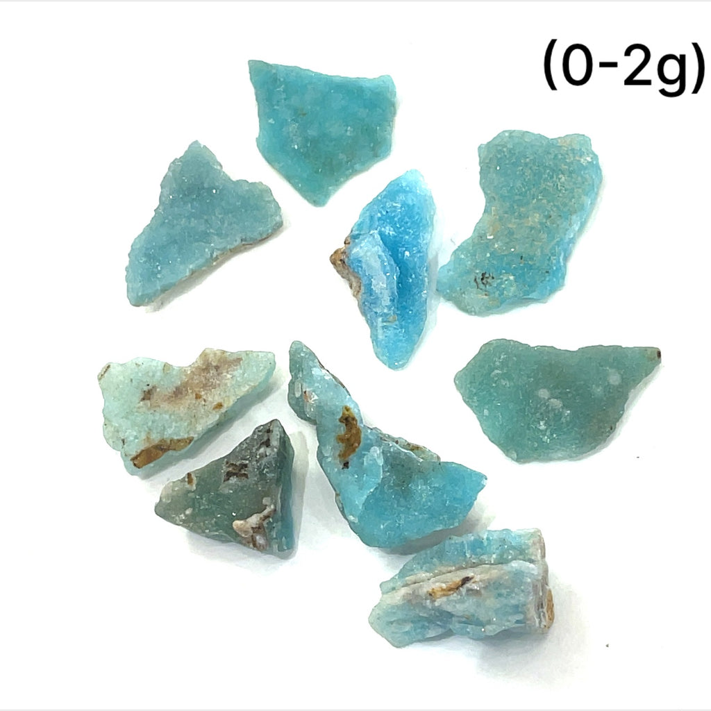 A group of (0-2g) of raw Hemimorphite pieces on  a white background, front view. 