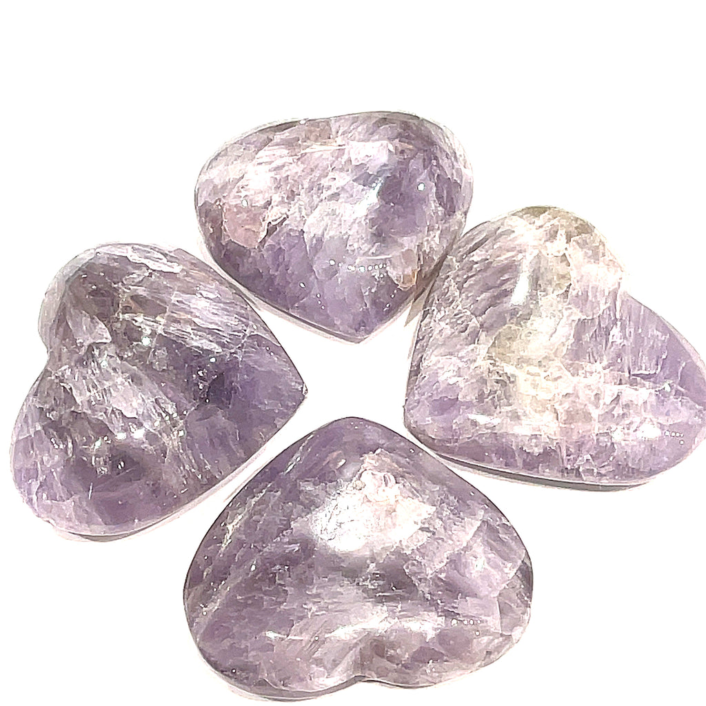 A group of 4 Super Seven gemstone heart carving, in a circle for a close-up, overview on a white background.