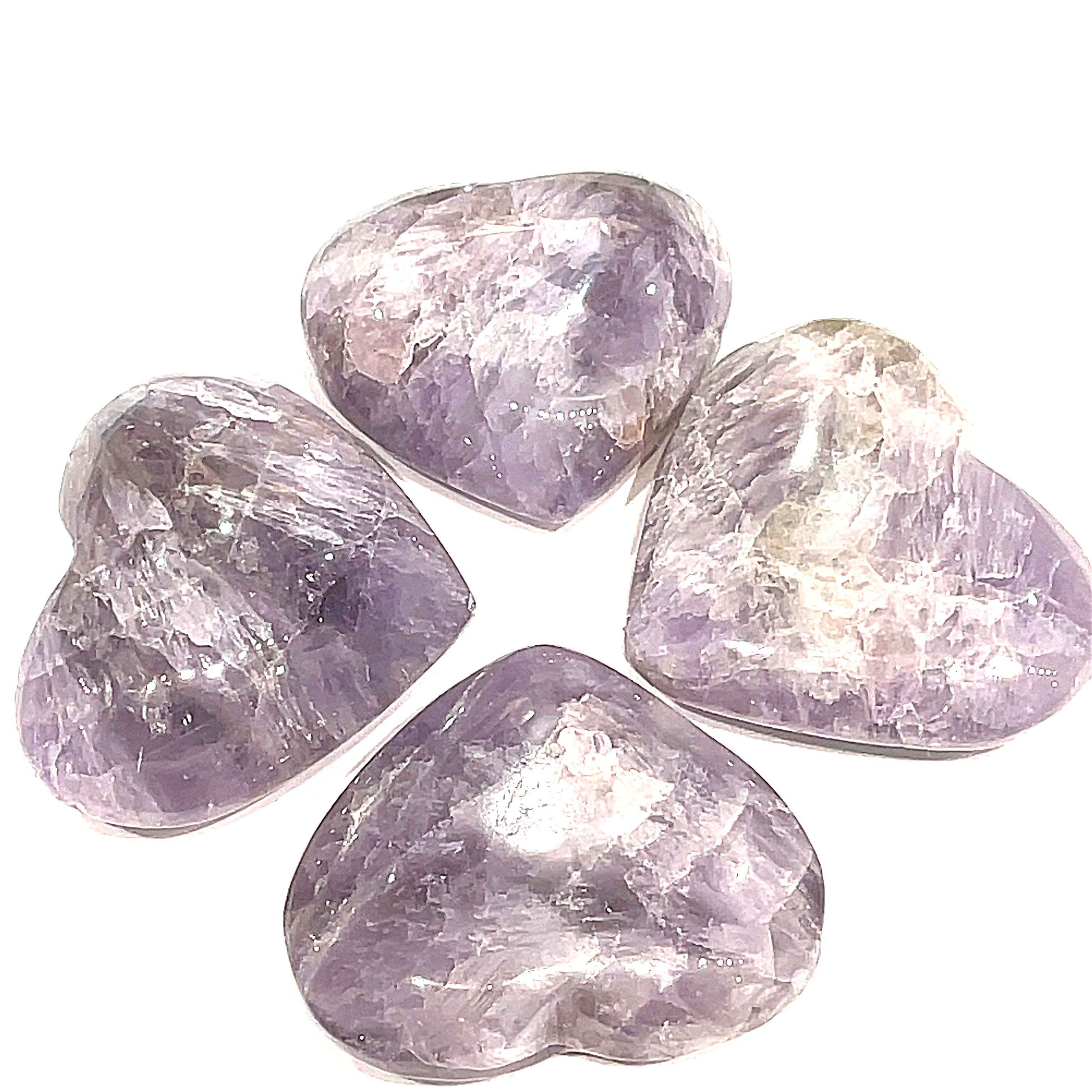 A group of 4 Super Seven gemstone heart carving, in a circle for a close-up, overview on a white background.