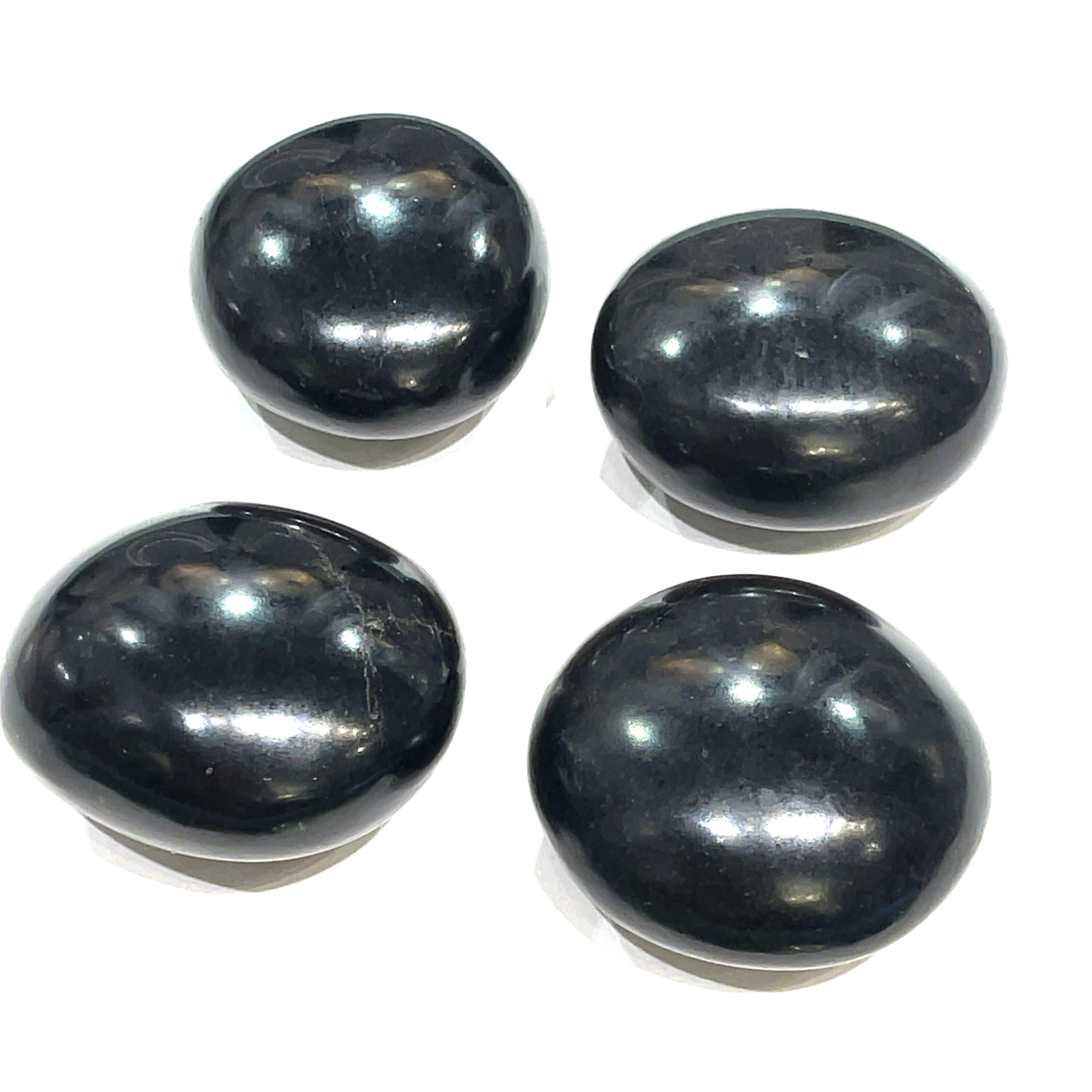 A group of Black Tourmaline gemstone palm stone on a white background, front overview. 