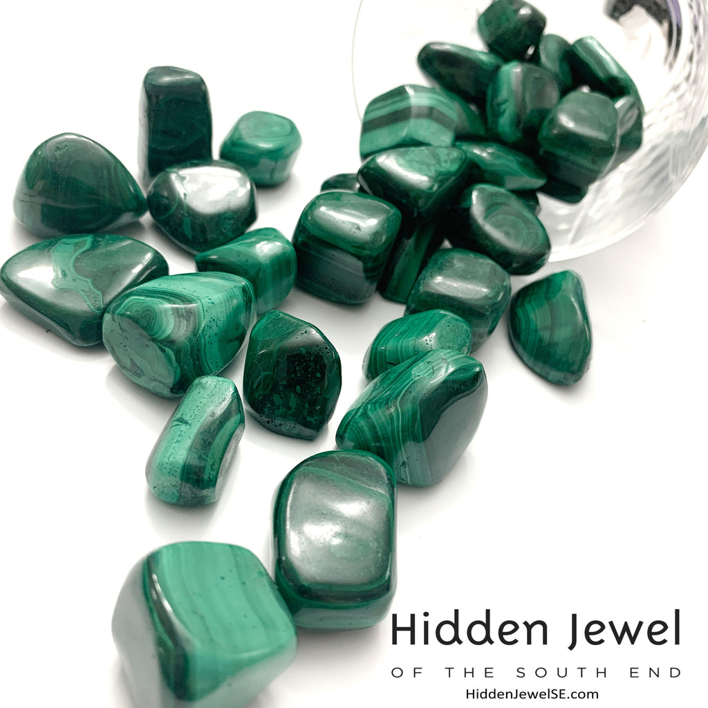 A group of Malachite tumbled gemstone  on a white background, front view. 