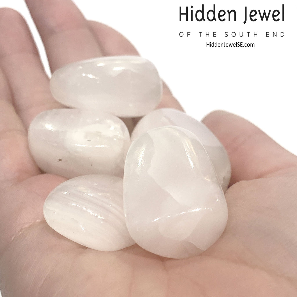 A group of Pink Calcite in a models palm on a white background, front view.