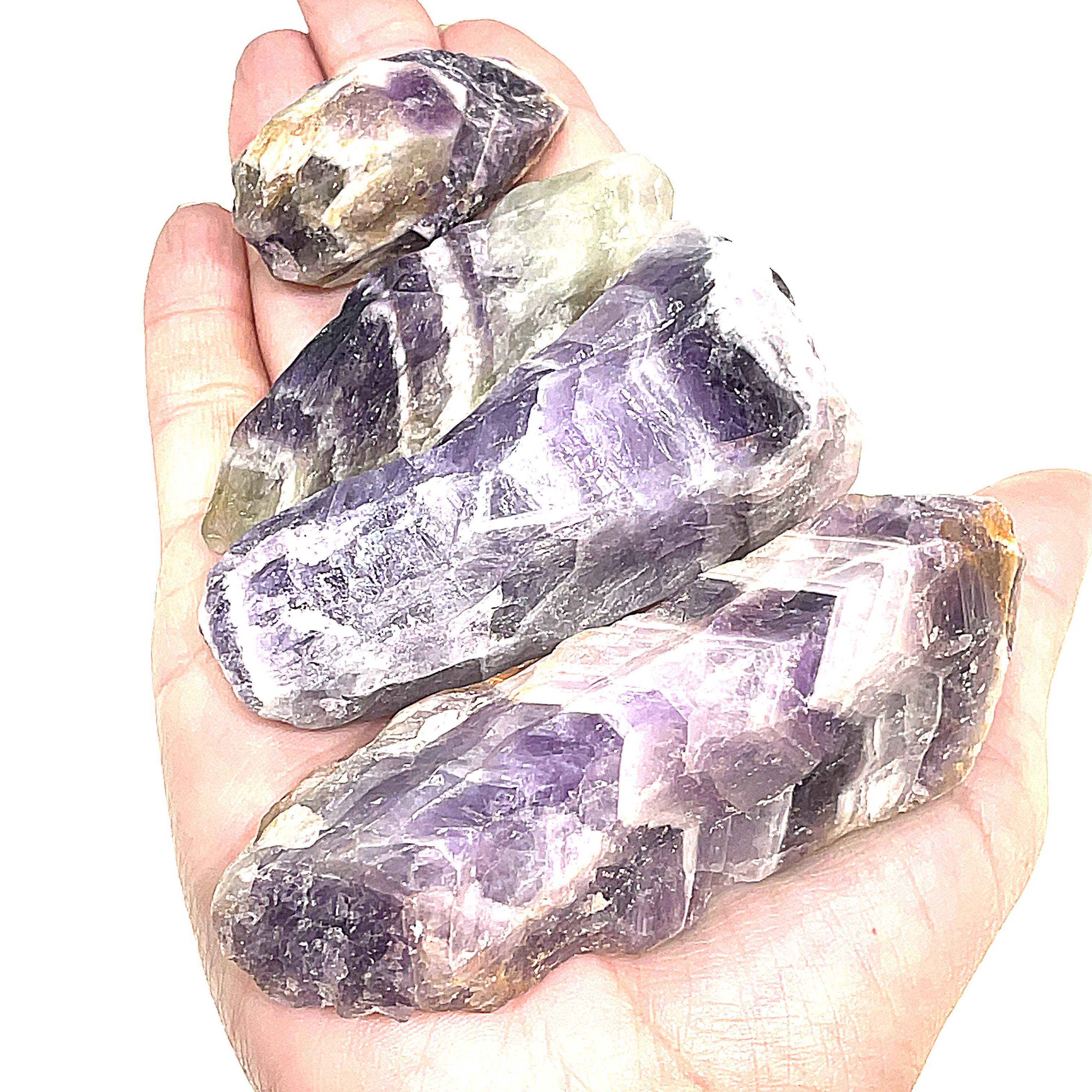A group of different  size raw Amethyst or Prasiolite gemstones on a white background, on a models palm, front overview.