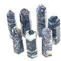 A group of ethically sourced Tiffany gemstone towers displayed against a white background, with varying shades of purple and white patterns, overview. 