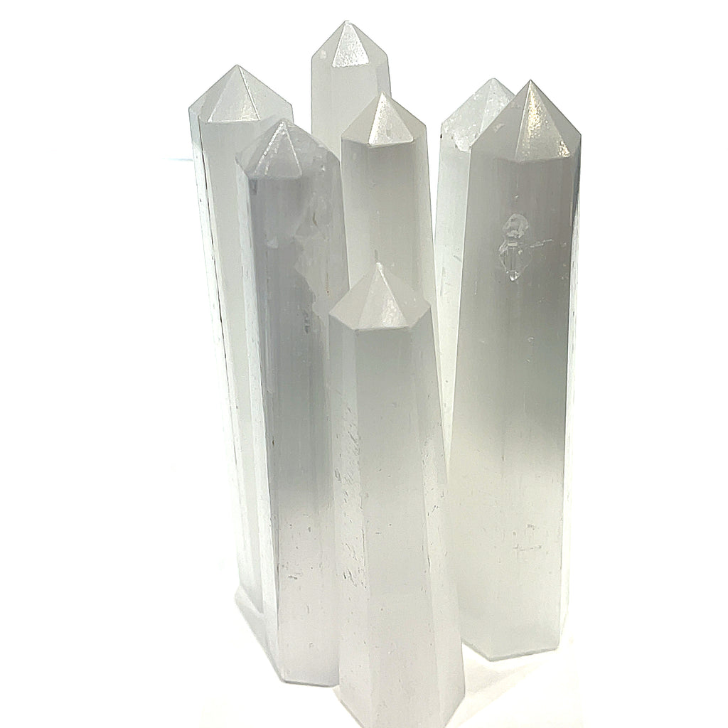 A group of selenite gemstone towers displayed together on a white background, front overview. 