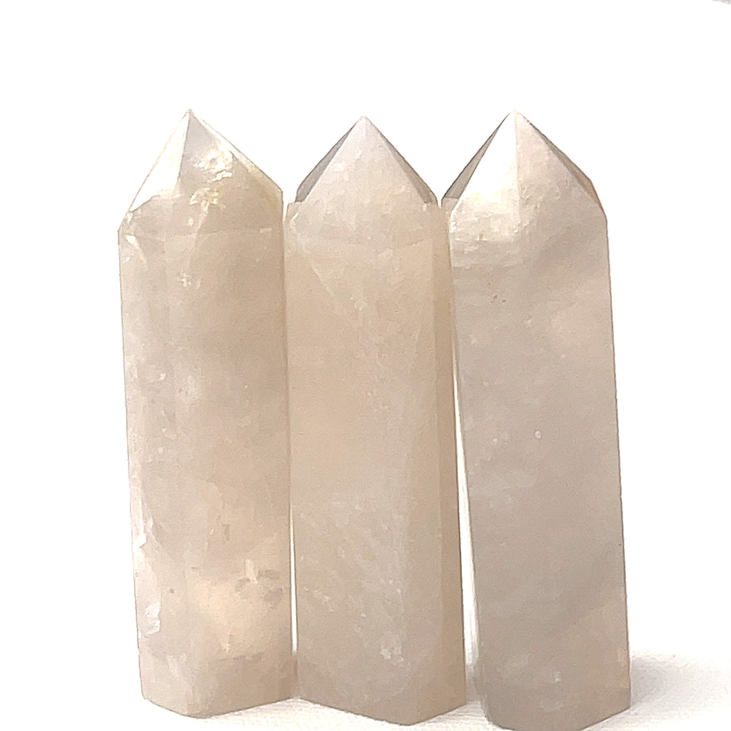 A group of three Blue Rose quartz gemstone towers arranged together against a white background, front overview. 