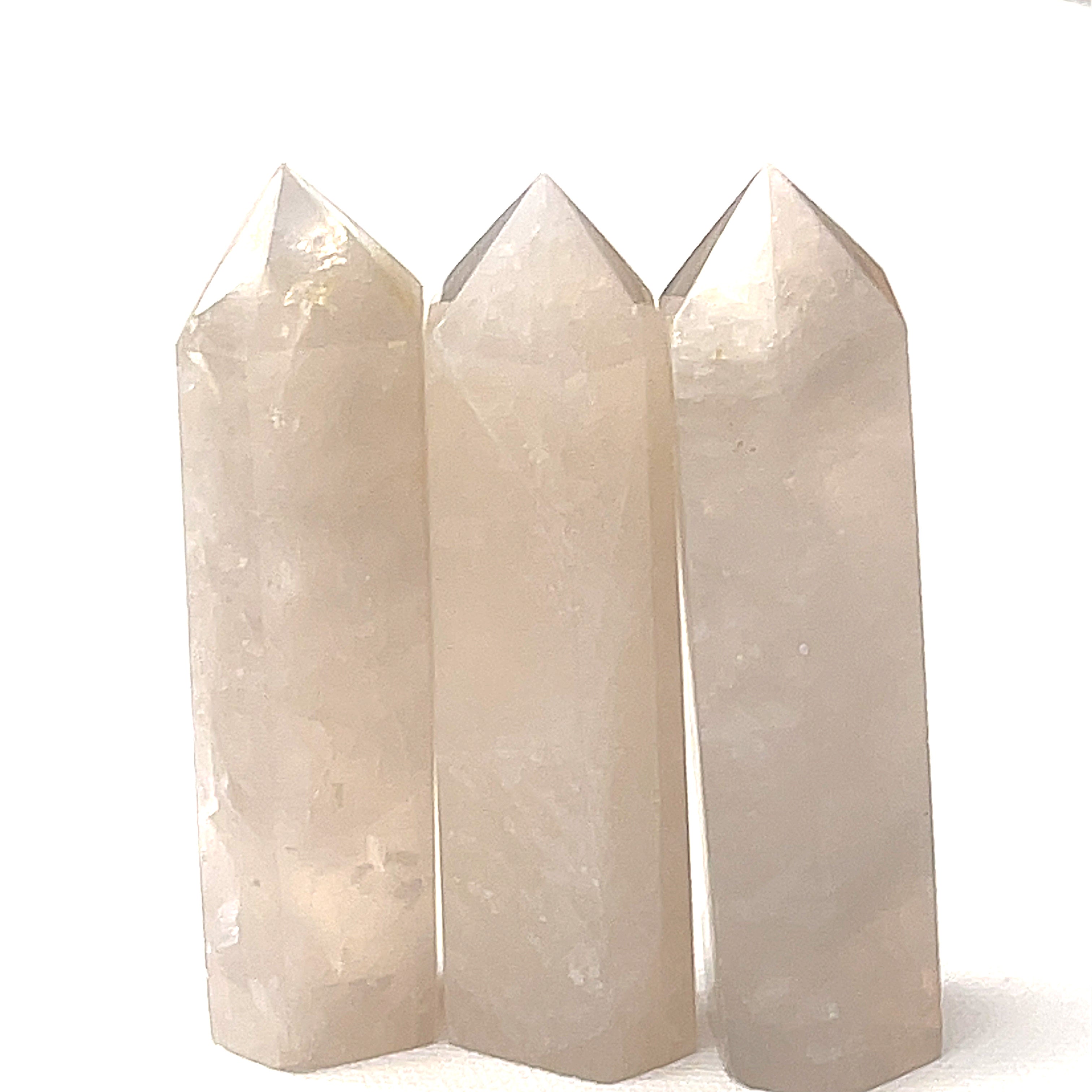 A group of three Blue Rose quartz gemstone towers arranged together against a white background, front overview. 