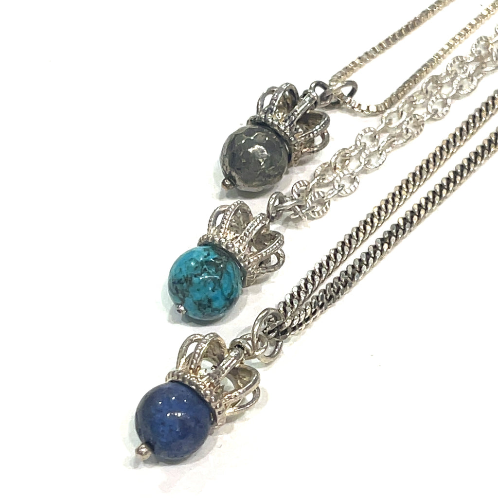 A group of three Sterling Silver Crown Pendant with pyrite, turquoise, and lapis lazuli gemstone on a white background, front overview. 