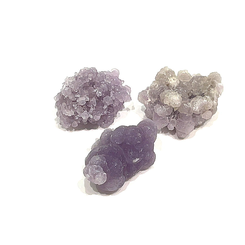 A group of three grape agate gemstone  on a white background, front close up overview. 