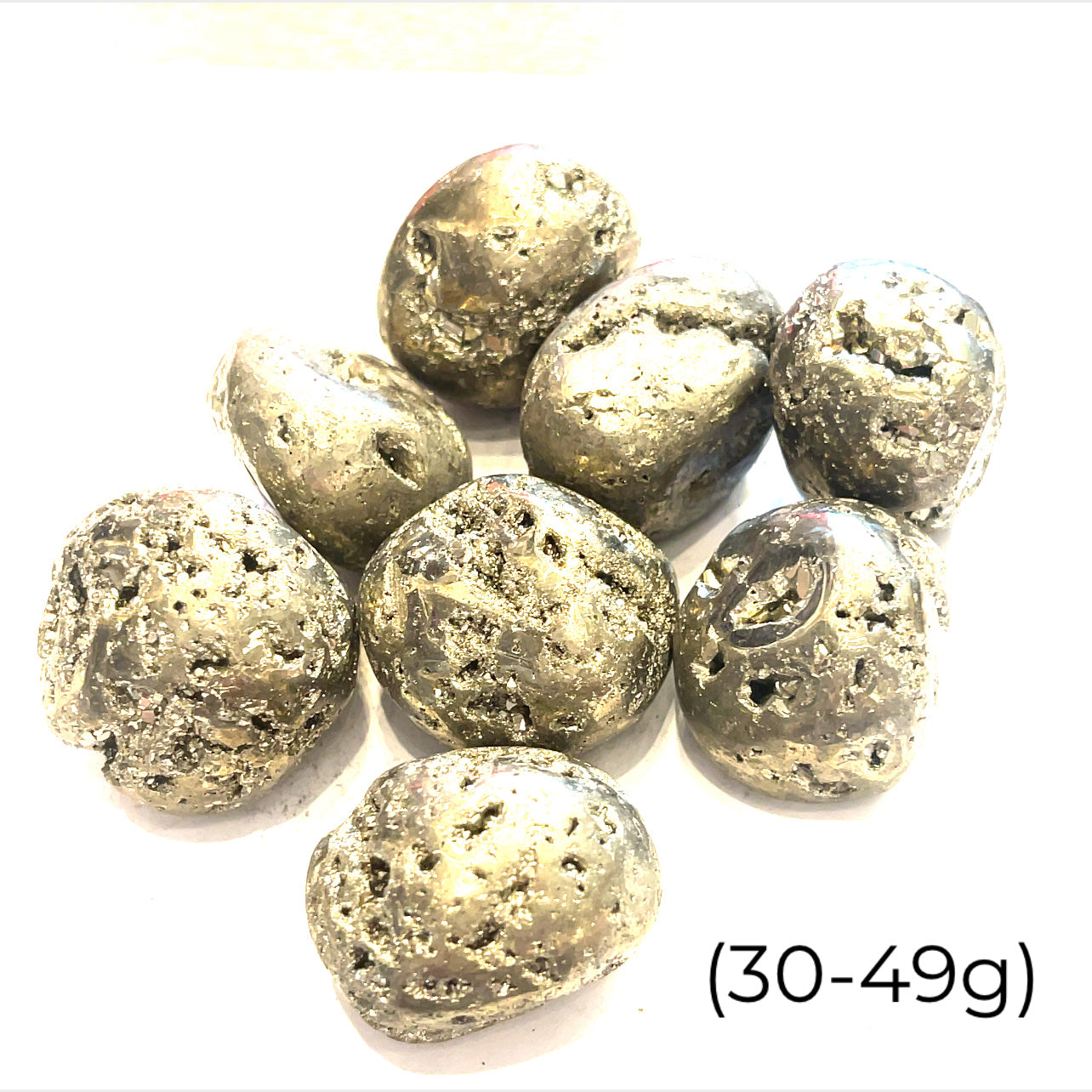 A group of tumbled Pyrite gemstones with a label indicating their weight range of 30-49 grams on a white background, front overview. 