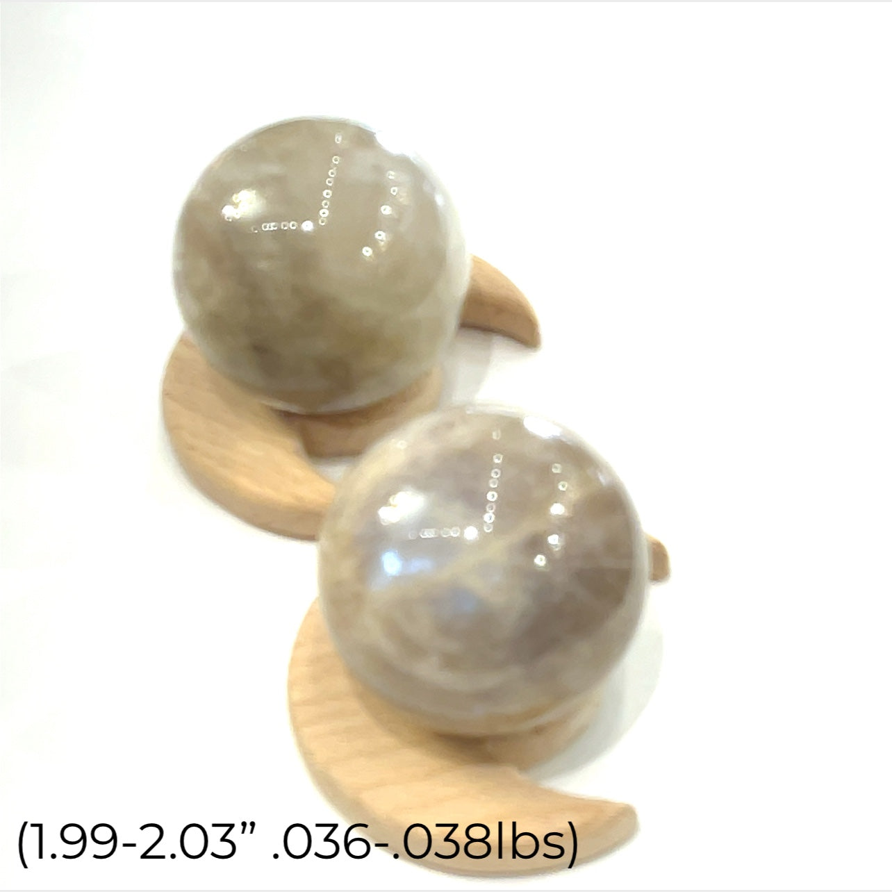 A grouping of  Grey Moonstone Sphere for meditation, balance, and chakra work (1.99''/.036-.038 lbs.)on a white background a close up view. 