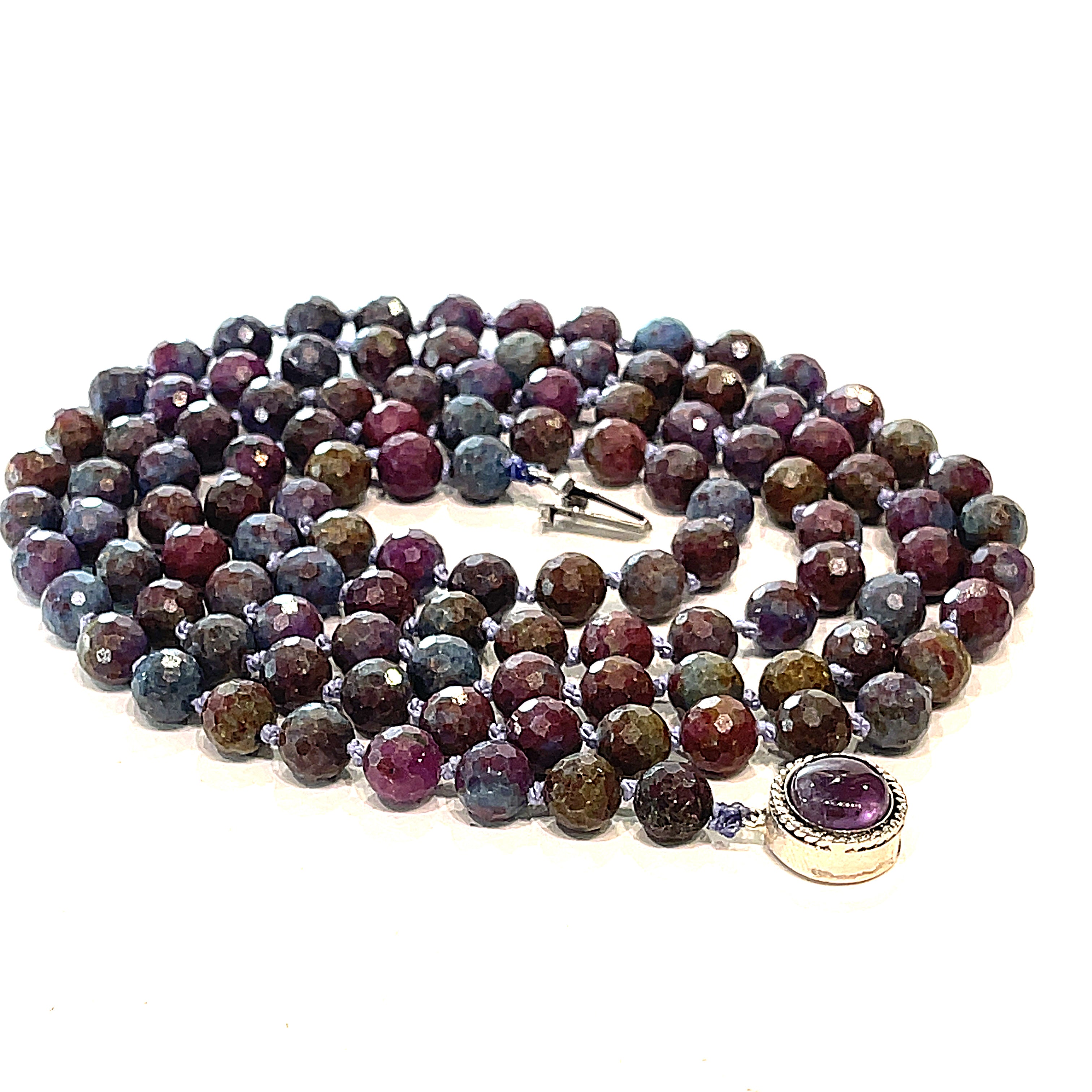 A knotted Ruby Kyanite gemstone necklace with a sterling silver amethyst box clasp, beads are 6mm faceted round, spiral overview on a white background.