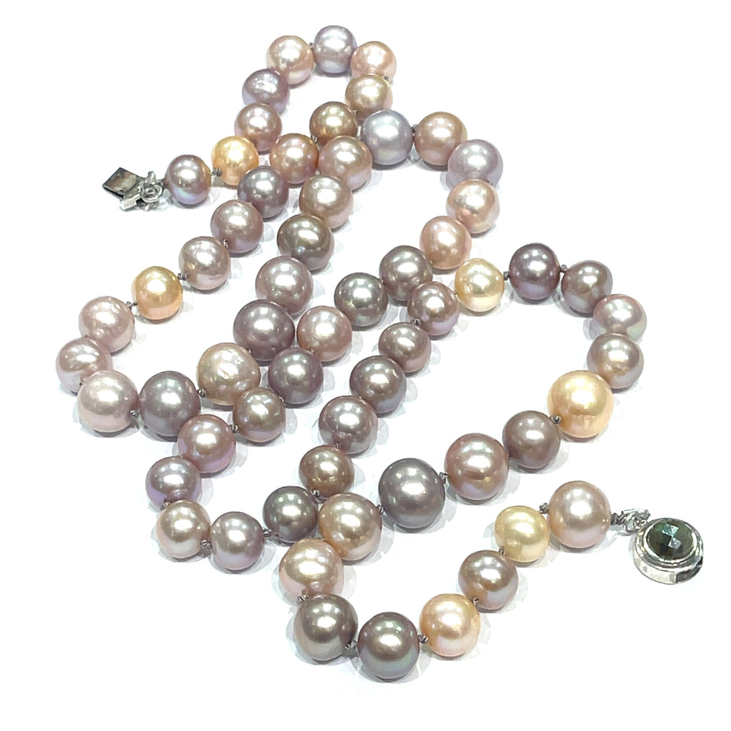 A knotted necklace featuring Edison pearls in varying shades of silver and gold, with a sterling silver box clasp and a bezel set labradorite gemstone. On a white background, center overview.