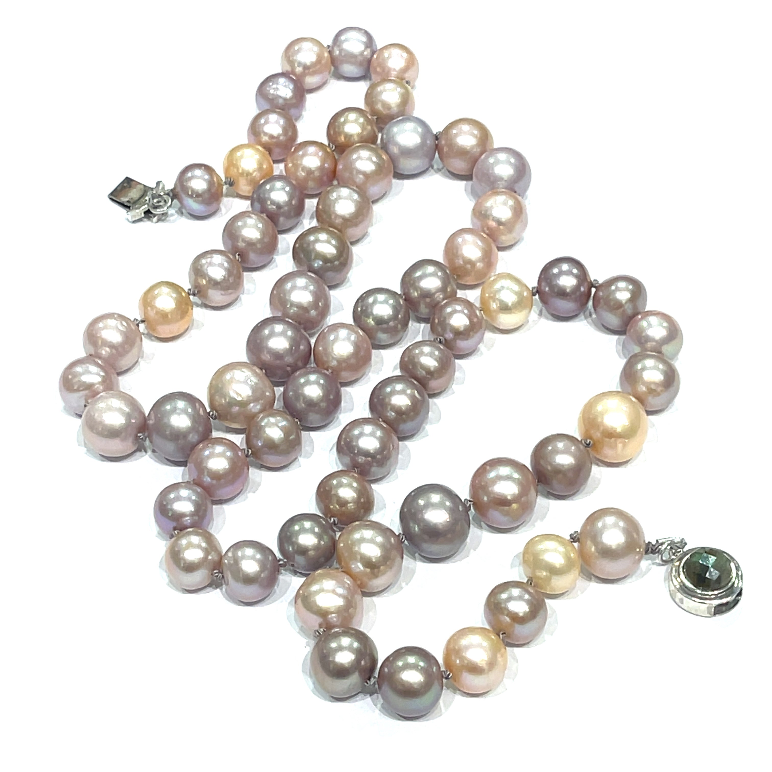 A knotted necklace featuring Edison pearls in varying shades of silver and gold, with a sterling silver box clasp and a bezel set labradorite gemstone. On a white background, center overview.