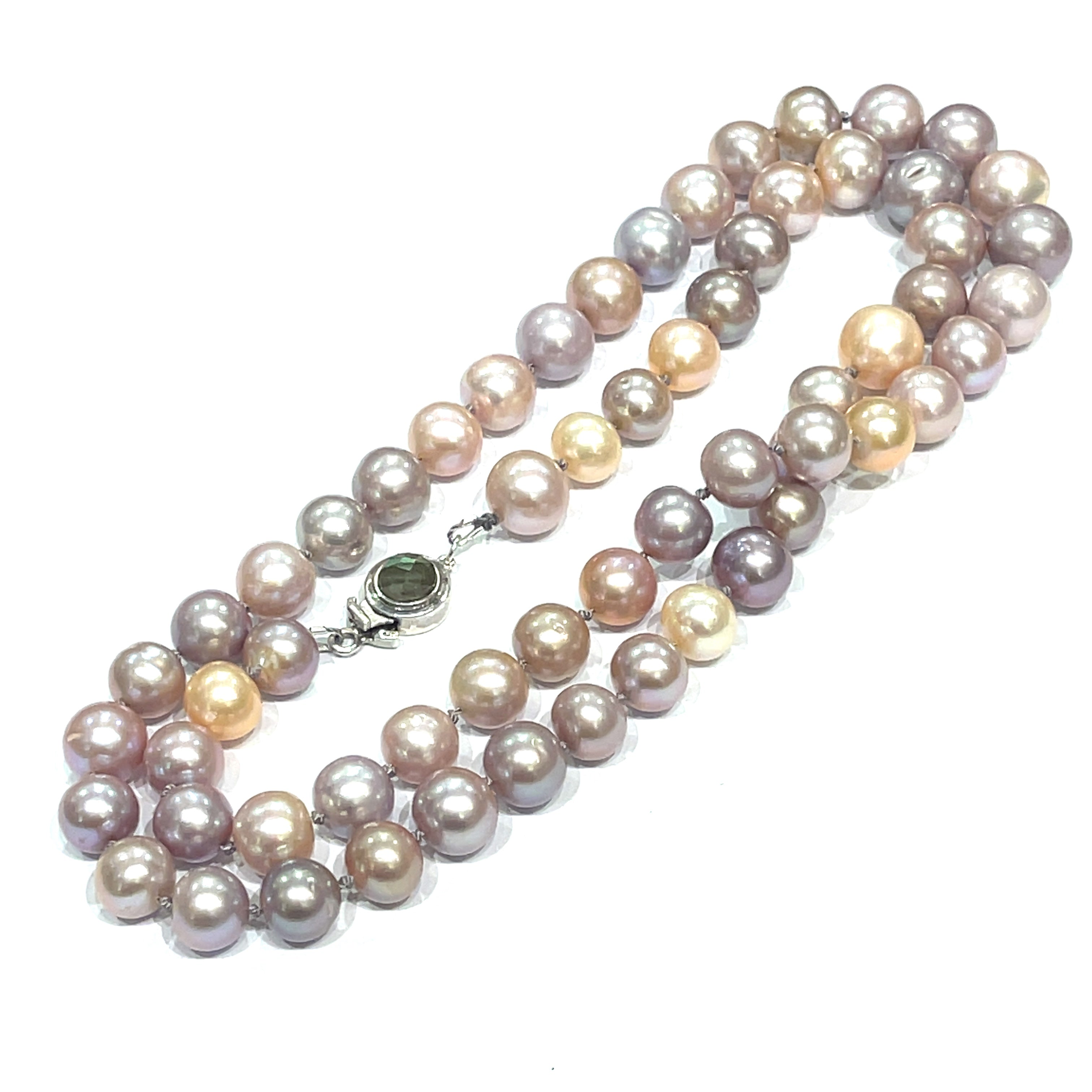 A knotted necklace featuring Edison pearls in varying shades of silver and gold, with a sterling silver box clasp and a bezel set labradorite gemstone. On a white background, long, center overview.