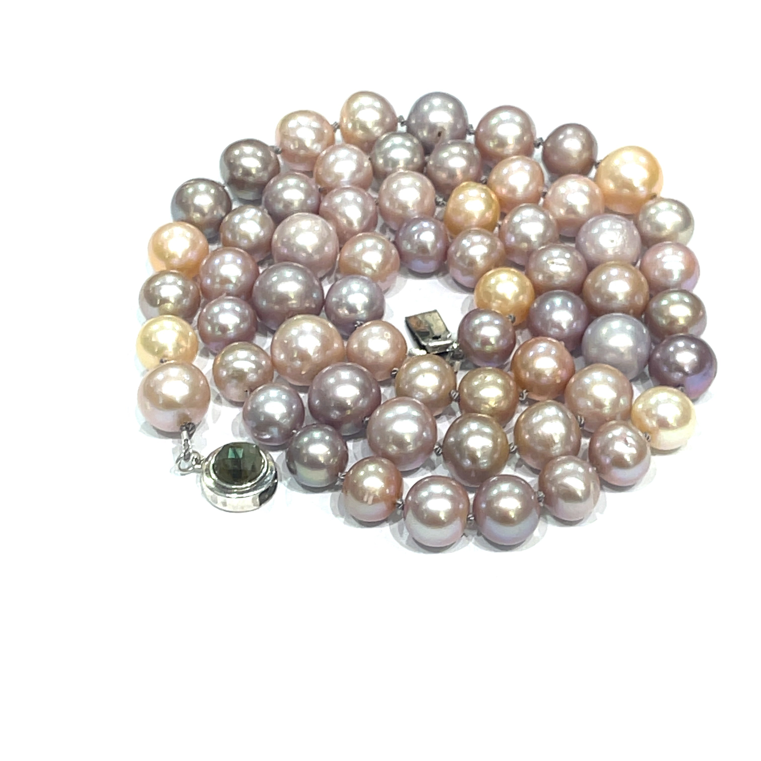 A knotted necklace featuring Edison pearls in varying shades of silver and gold, with a sterling silver box clasp and a bezel set labradorite gemstone. On a white background, spiral overview.