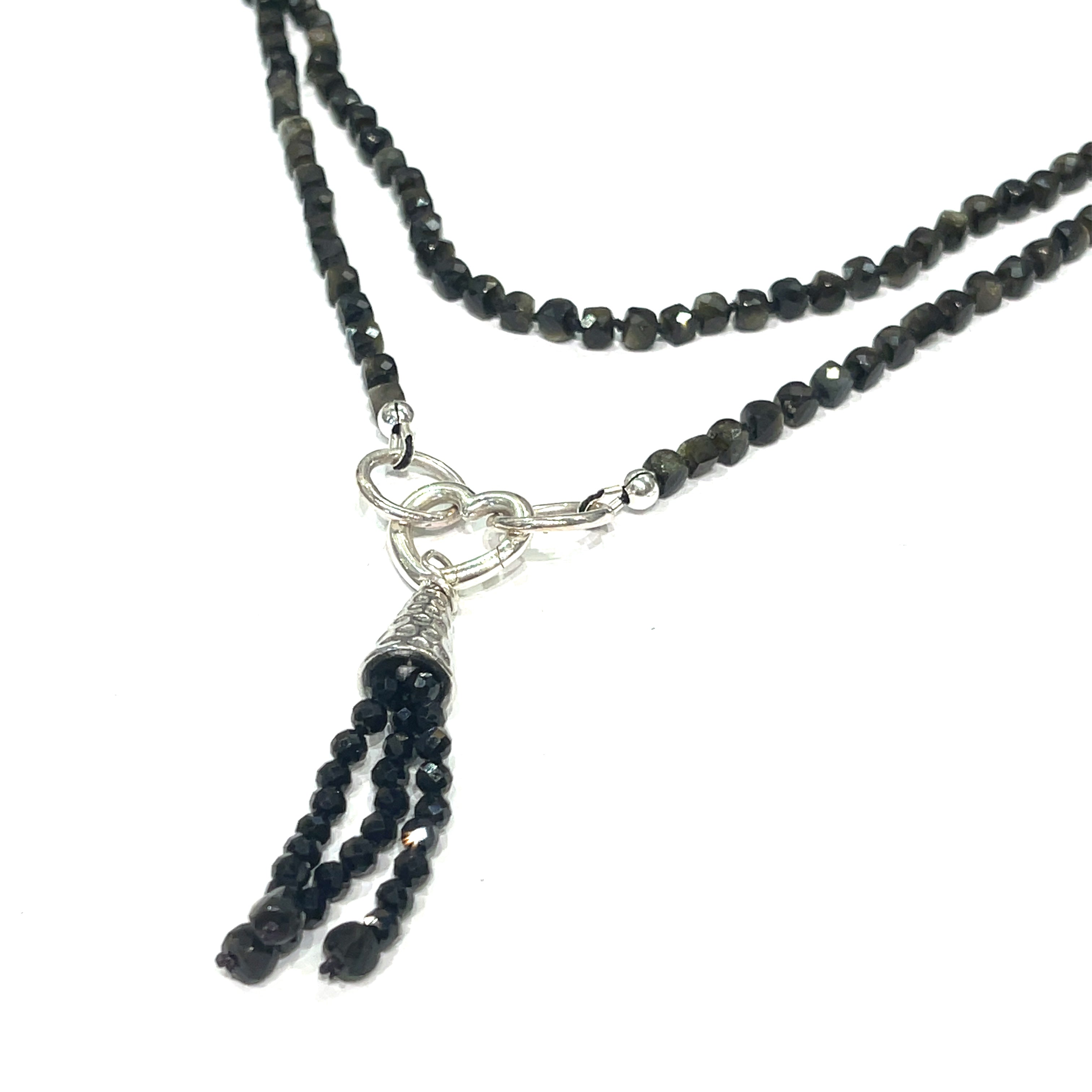A knotted necklace made of Golden Sheen Obsidian gemstones with a tassel, featuring silver accents. On a white background, a hanging long overview. 