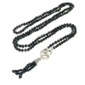 A knotted necklace made of Golden Sheen Obsidian gemstones with a tassel, featuring silver accents. On a white background, a long, center view overview. 