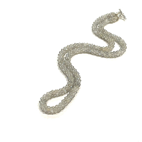 A labradorite gemstone crocheted necklace with a sterling silver toggle. Displayed on a white background, long, center overview. 