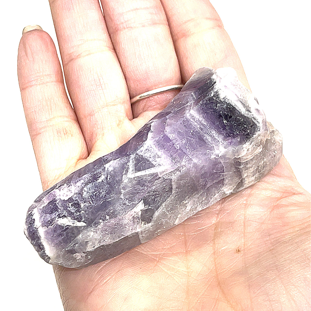 A  large size raw Amethyst or Prasiolite gemstones on a white background, on a models palm, front overview.