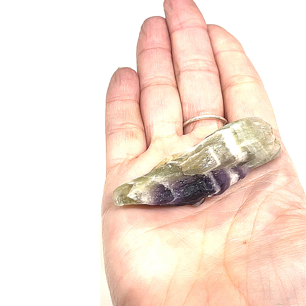 A  medium size raw Amethyst or Prasiolite gemstones on a white background, on a models palm, front overview.
