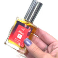 A model holding a bottle of 'Self Love: Hidden Jewel of the South End' body spray with a colorful label, on a white background, and front view.