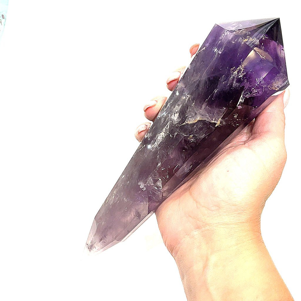 A model holding an extra-large Amethyst Quartz Vogel Gemstone on a white background, front view. 