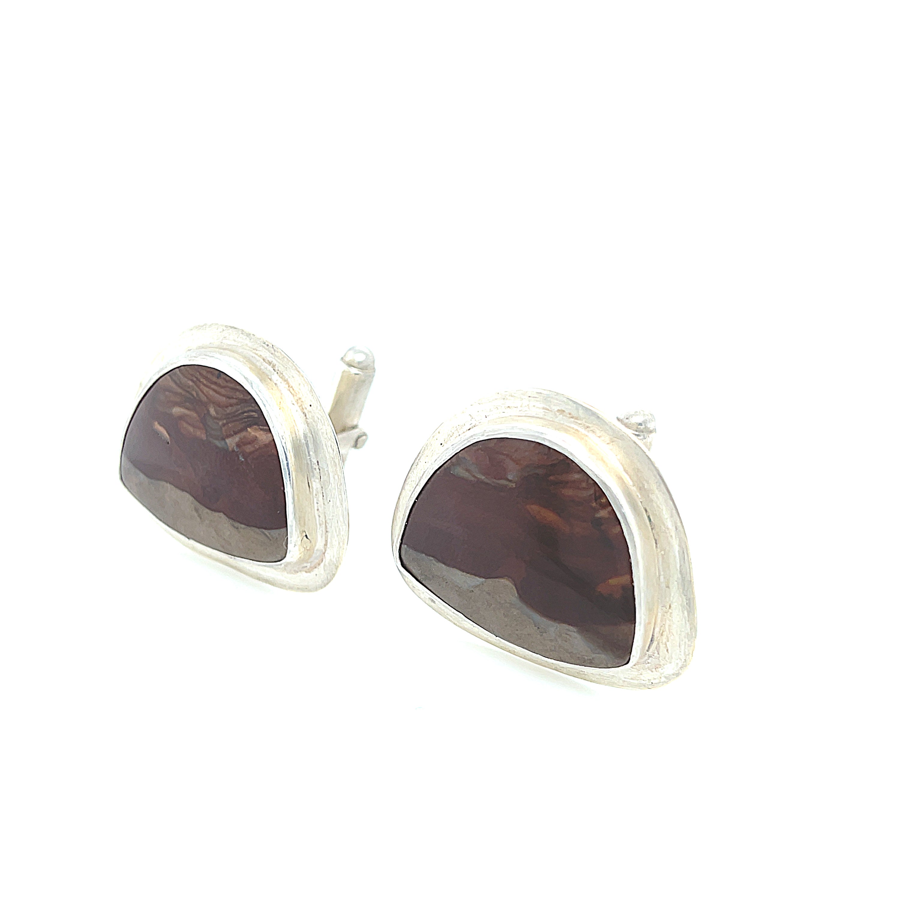A pair of sterling silver cufflinks featuring rounded-triangle-shaped mookite jasper gemstones, bezel-set in a round sterling silver setting. On a white background, close up left angle view.