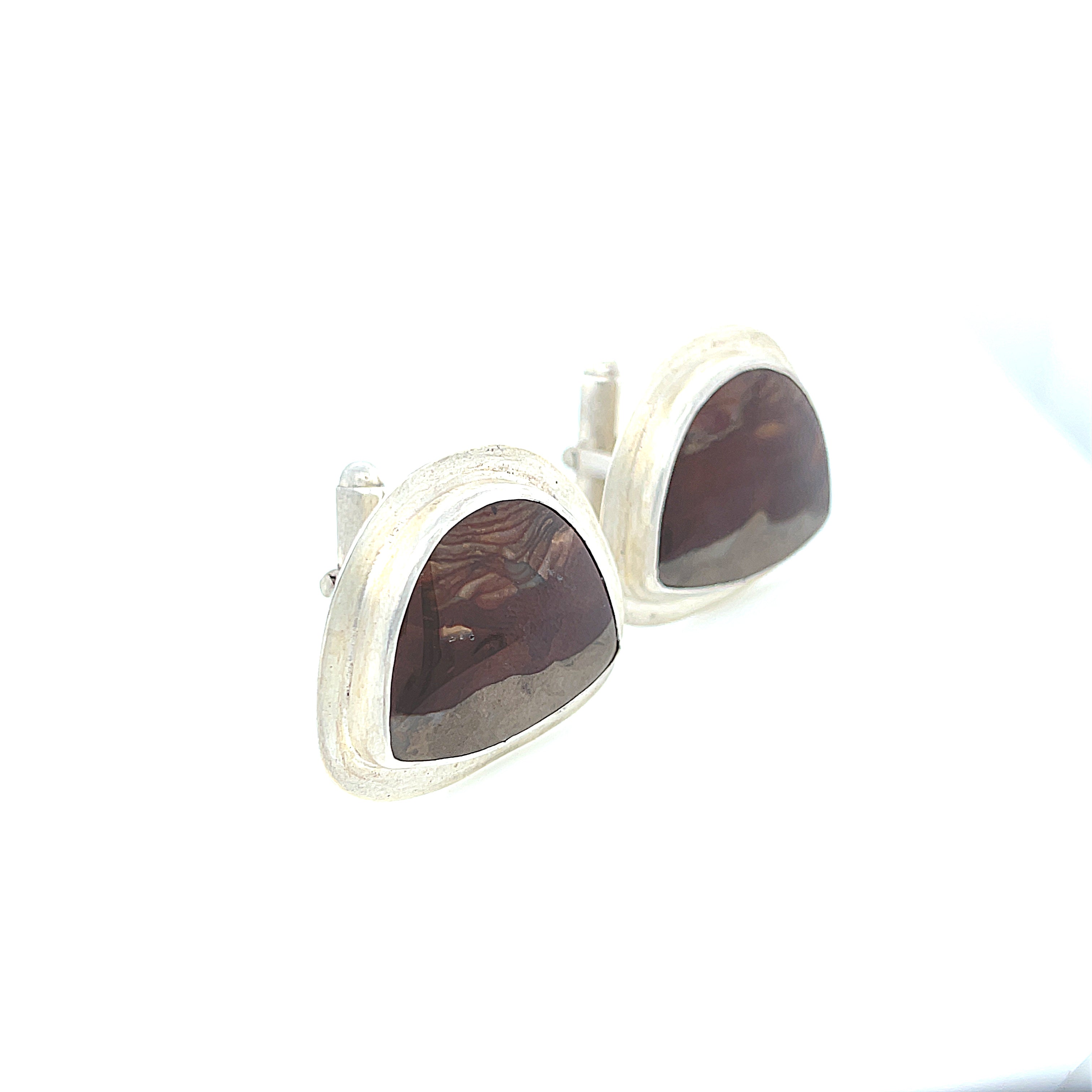 A pair of sterling silver cufflinks featuring rounded-triangle-shaped mookite jasper gemstones, bezel-set in a round sterling silver setting. On a white background, close up right angle view.