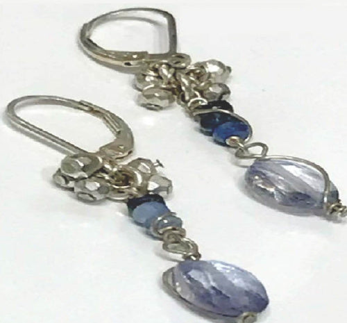 A pair of wire-wrapped earrings featuring silver wire, clear beads, and blue stones on a white background, center-diagonal overview.