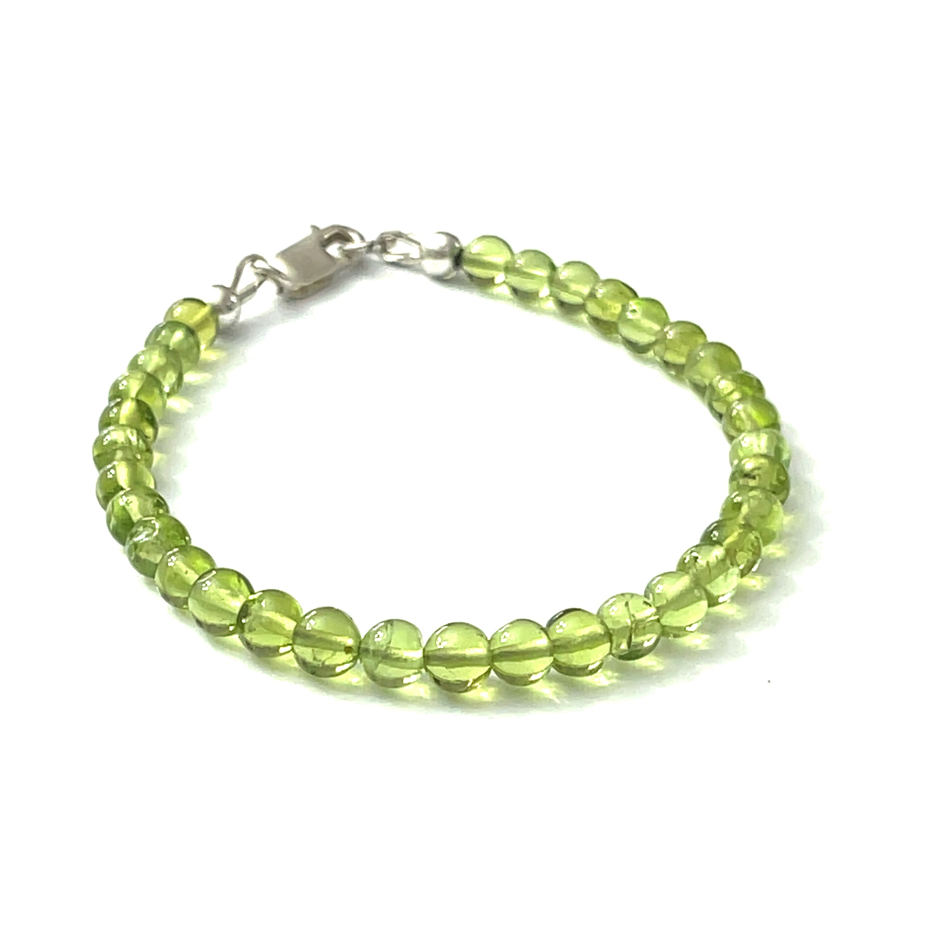 A peridot gemstone 6mm smooth round with a Sterling silver lobster claw on a white background front center overview.