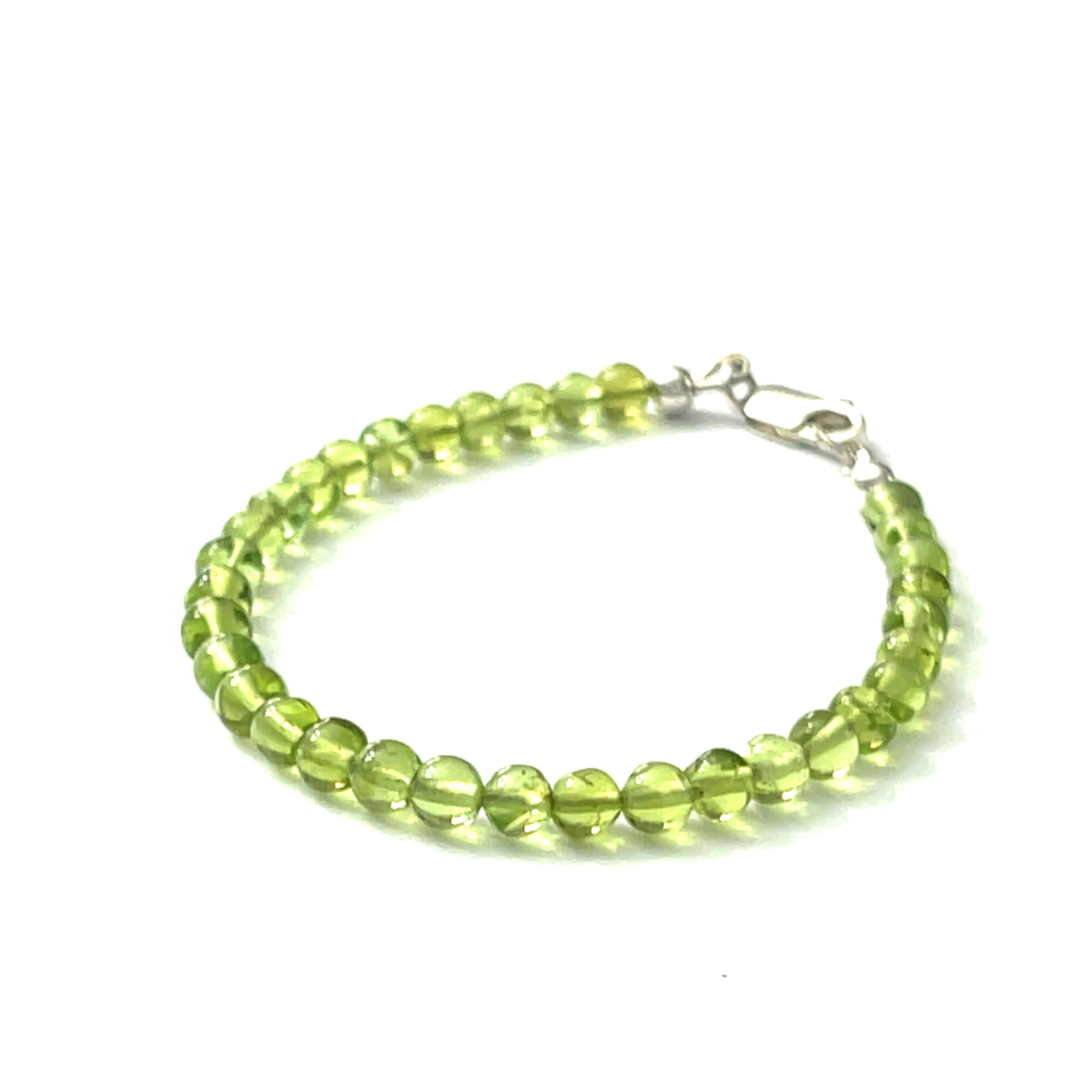 A peridot gemstone 6mm smooth round with a Sterling silver lobster claw on a white background front right angle center overview.